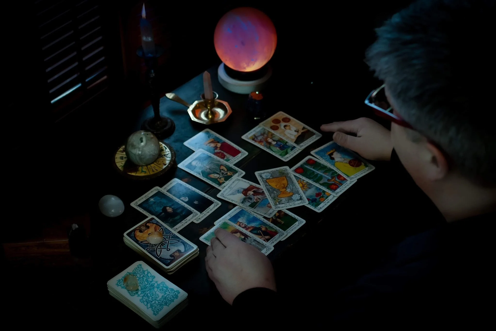 a tarot reader looking at a spread of cards on a table
