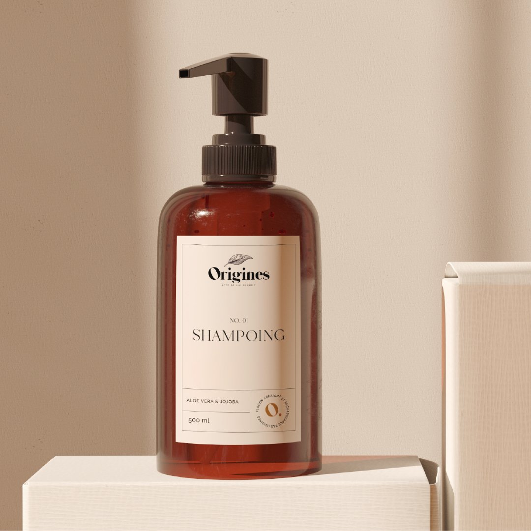 Bouteille de shampooing marron avec un bouchon à pompe, étiquette blanc avec texte en français, posée sur une surface blanche contre un mur beige.