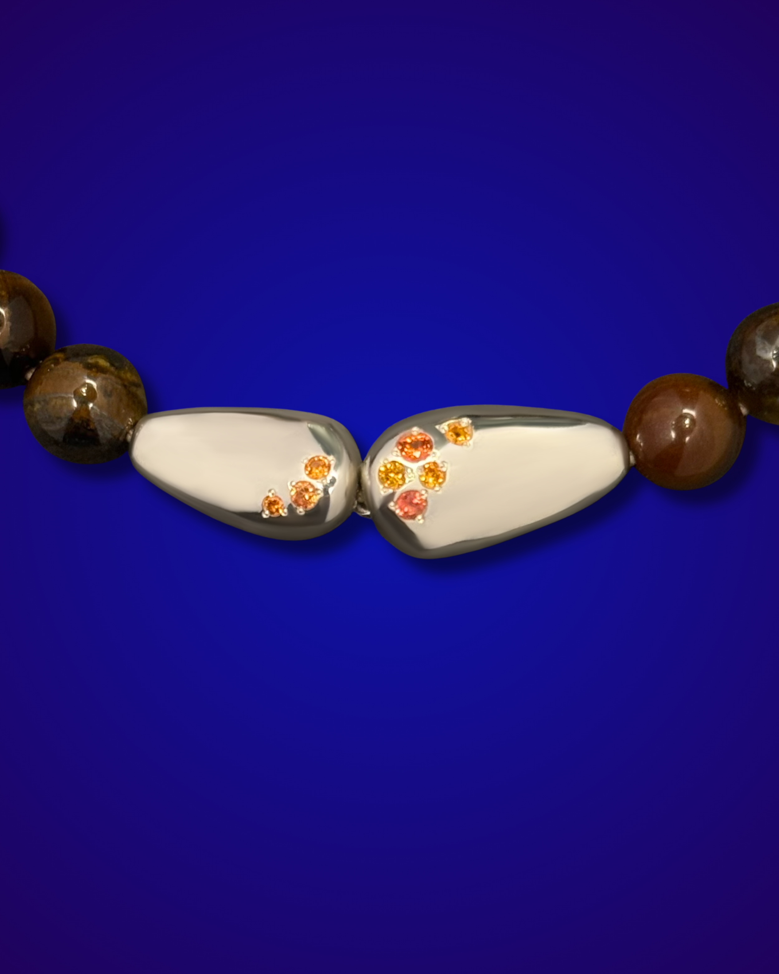 Bracelet GALETS argents et gemmes précieuses, sur fond bleu