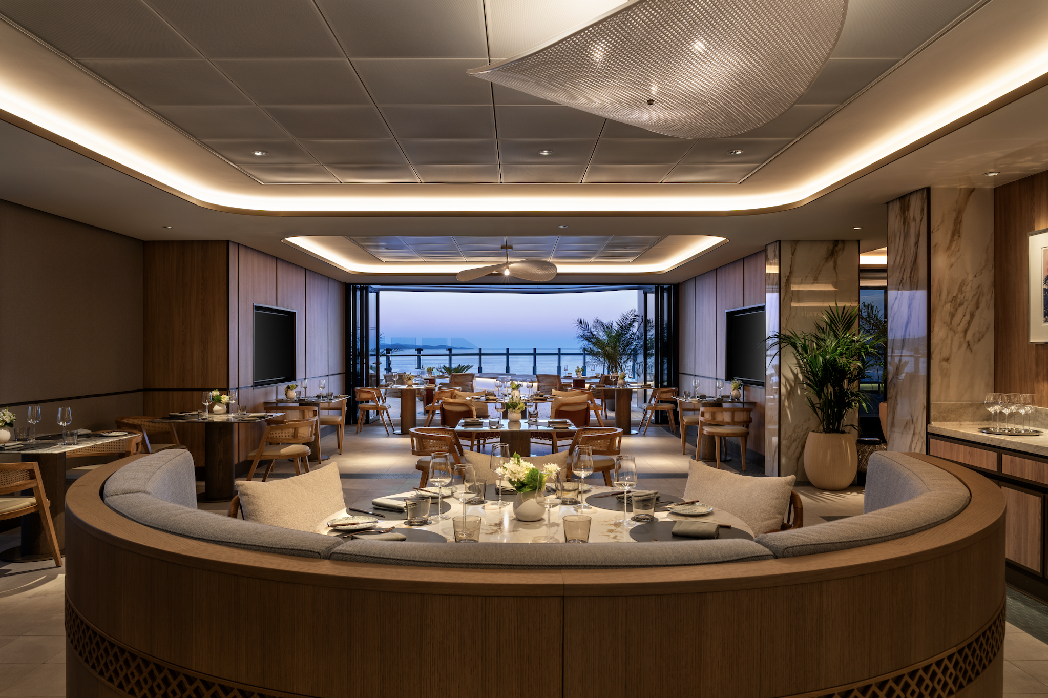Elegant main dining room aboard The Ritz-Carlton Yacht Collection, offering refined cuisine with panoramic ocean views.
