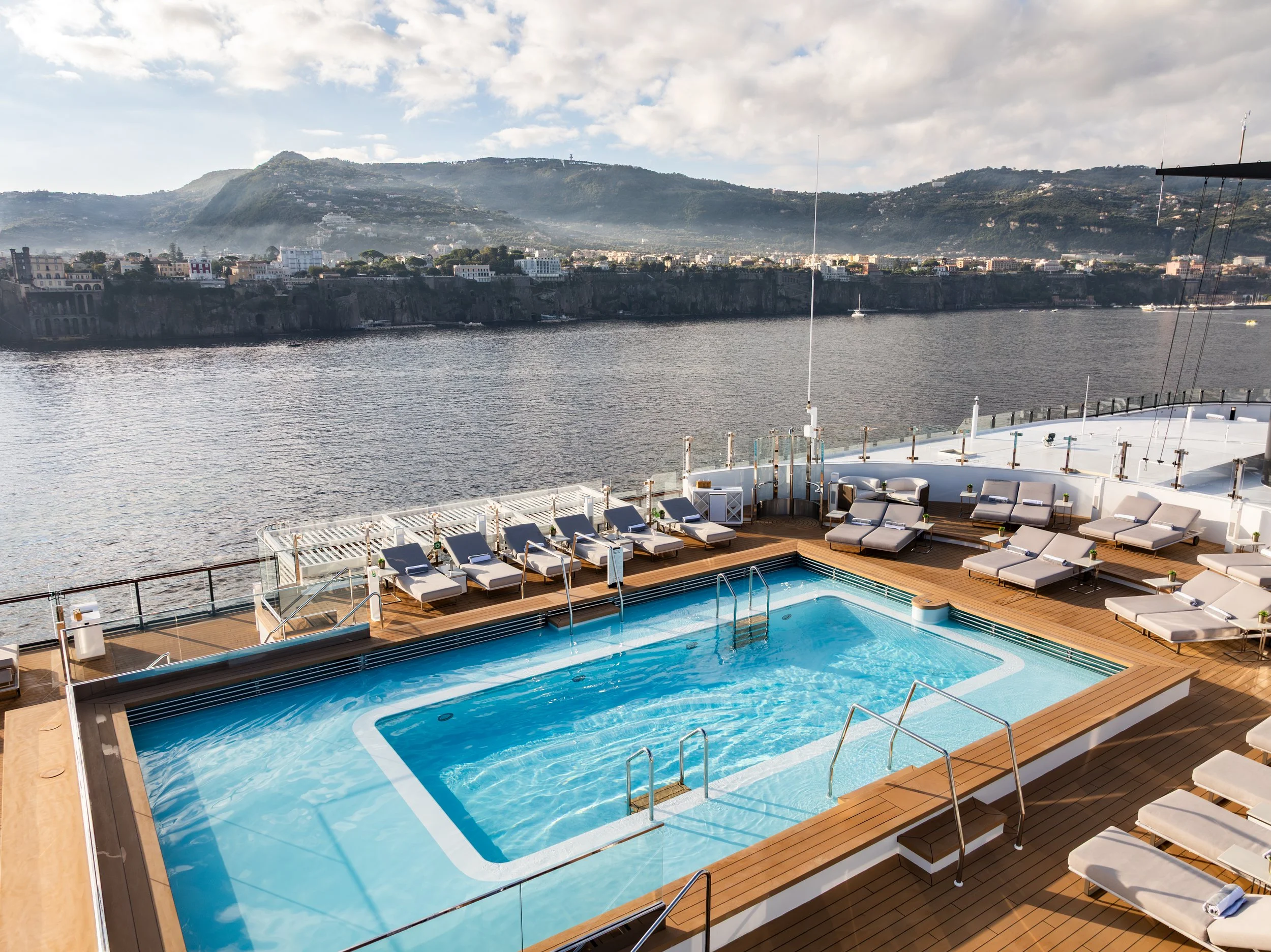Infinity-style pool deck aboard The Ritz-Carlton Yacht Collection overlooking the coastline of Sorrento, Italy.