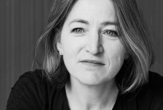 Black and white portrait of a woman with shoulder-length hair, looking slightly to the side with a contemplative expression.