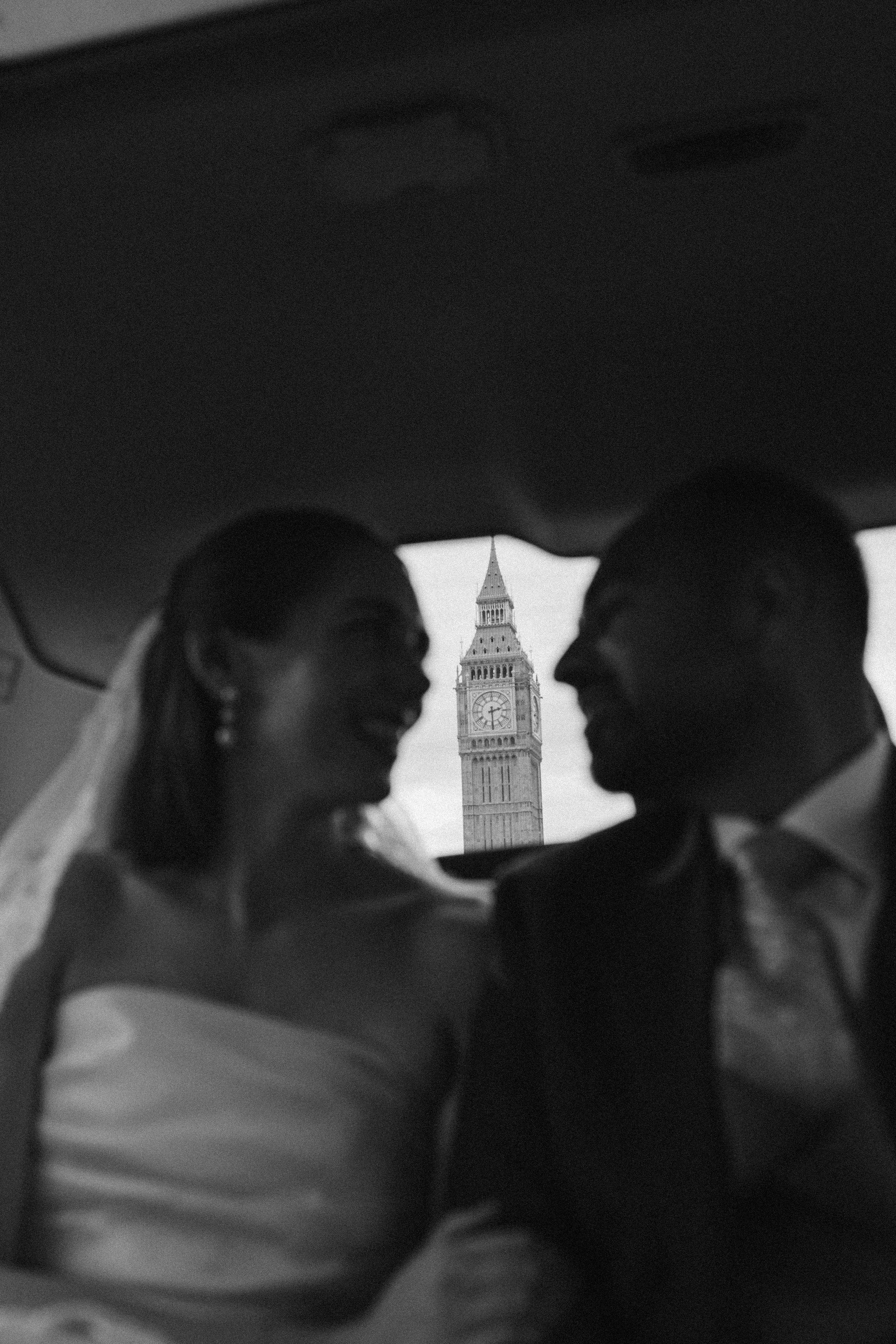 Silhouettes of a bride and groom facing each other with Big Ben clock tower in the background.