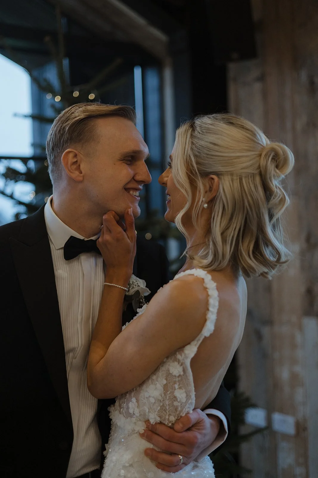 A bride and groom smiling closely at each other during their wedding reception.