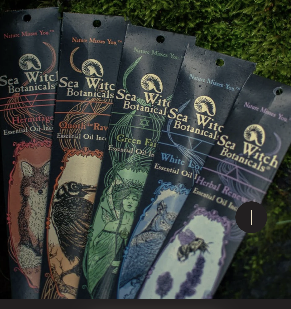 Five packets of Sea Witch Botanicals essential oil blends arranged in a fan, featuring designs with animals, a woman, and nature themes, against a greenery background.