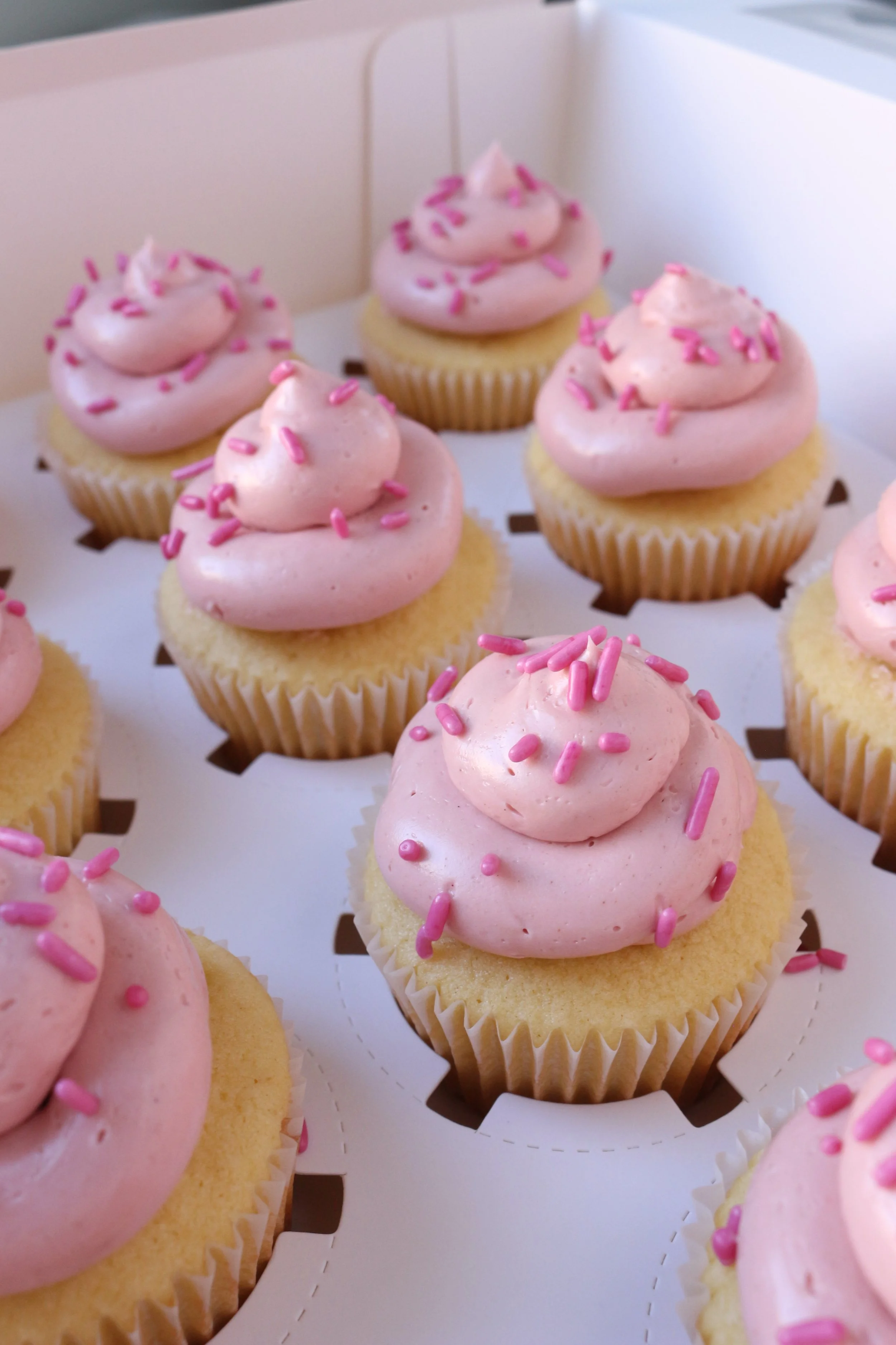 Made by Cakes by Caroline. Pink cupcakes with swirls and sprinkles. One dozen cupcakes to three dozen cupcakes. Celebration ready.