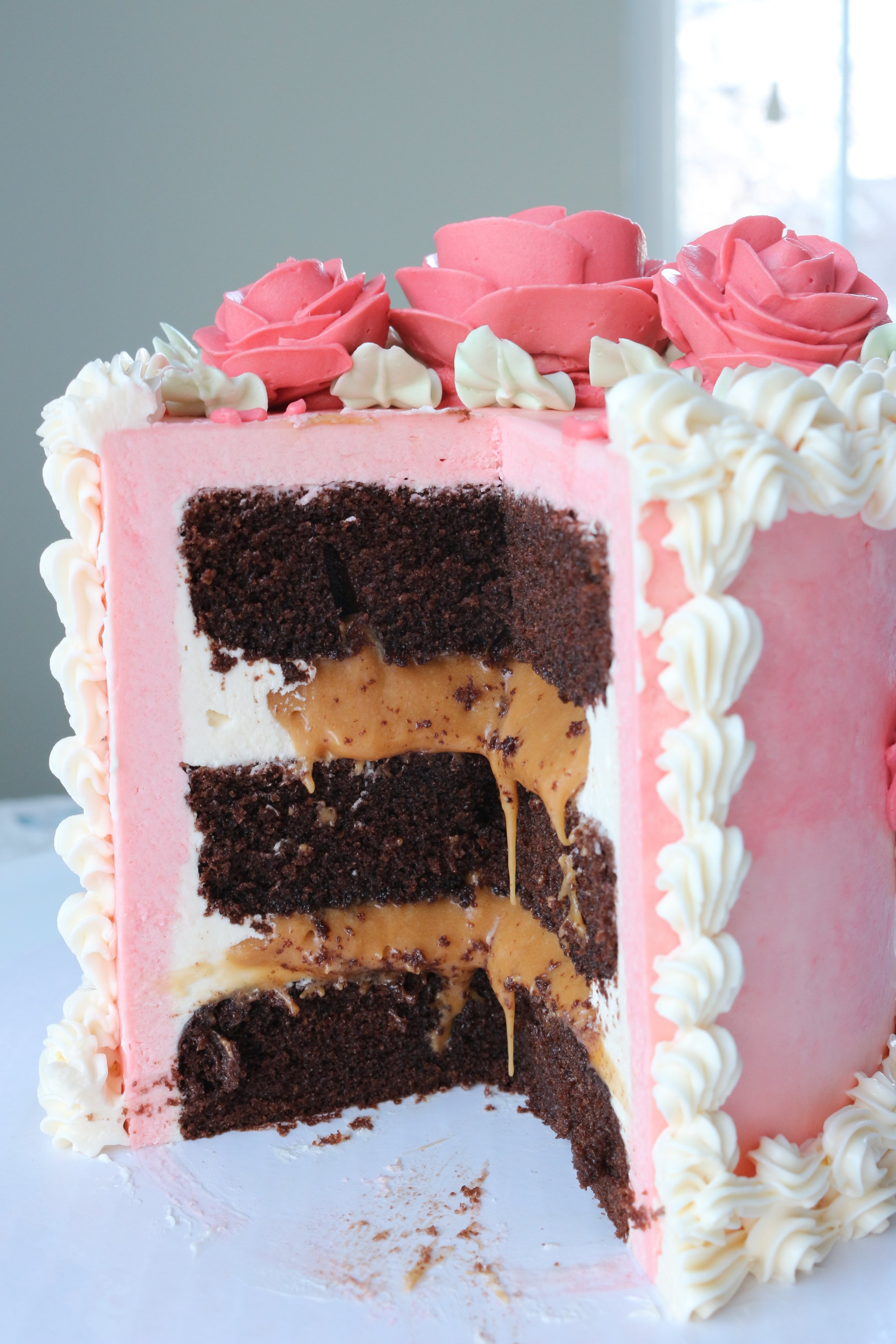 Cut open cake to see chocolate layers and caramel filling. Vintage piping on a Valentine's Day Cake. Cakes by Caroline.