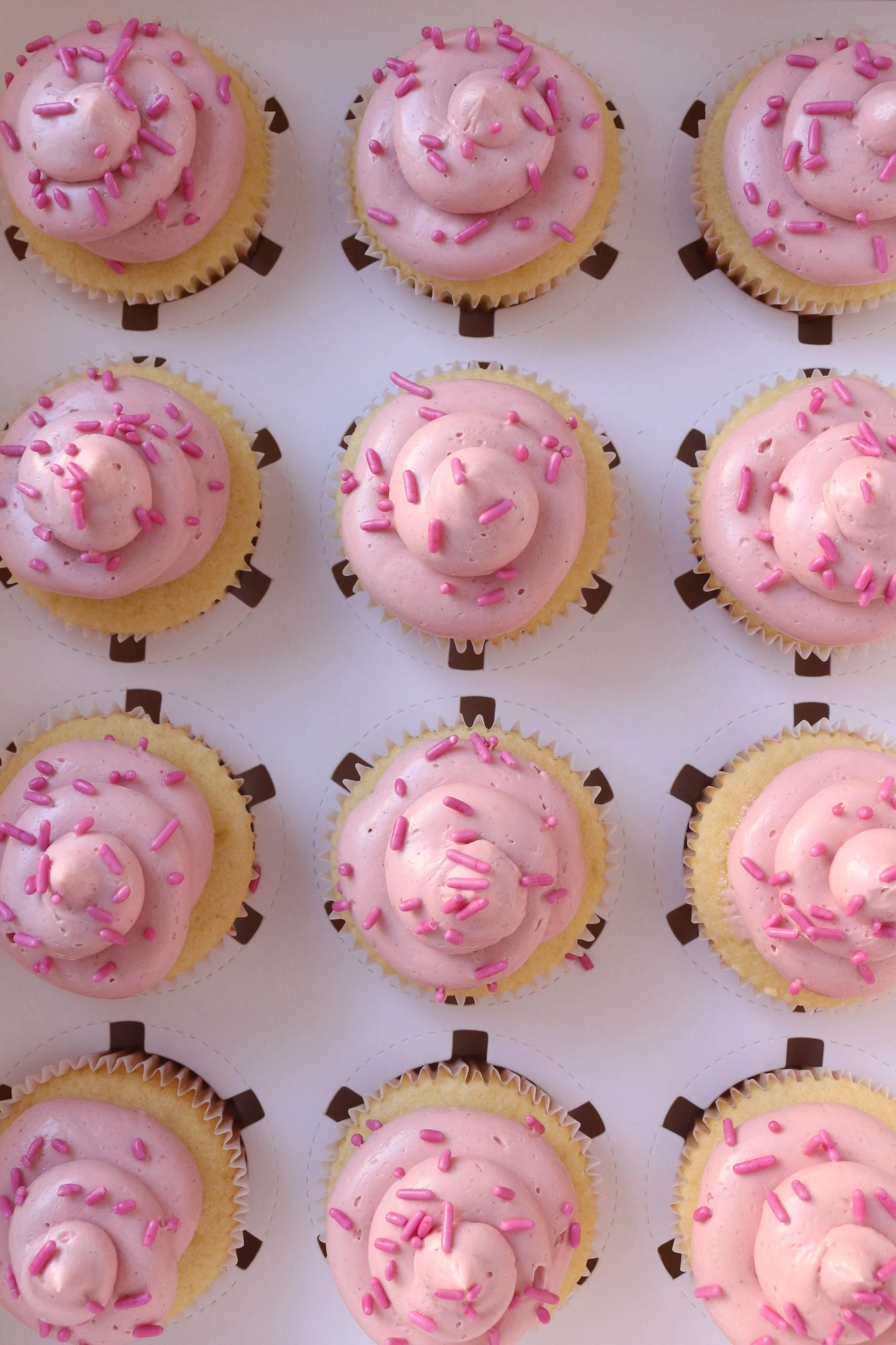 Made by Cakes by Caroline. Pink cupcakes with swirls and sprinkles. One dozen cupcakes to three dozen cupcakes. Celebration ready.