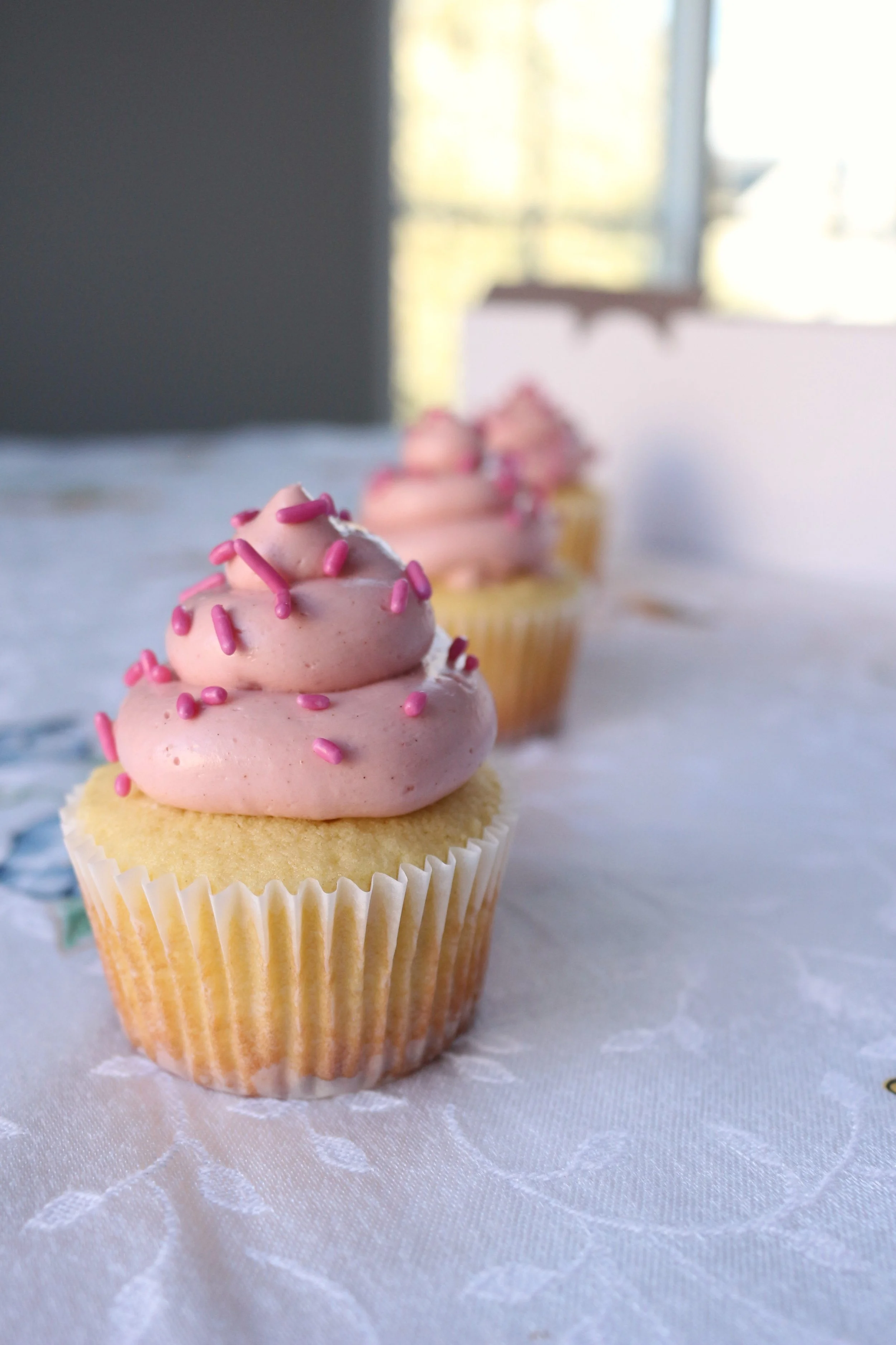 Made by Cakes by Caroline. Pink cupcakes with swirls and sprinkles. One dozen cupcakes to three dozen cupcakes. Celebration ready.