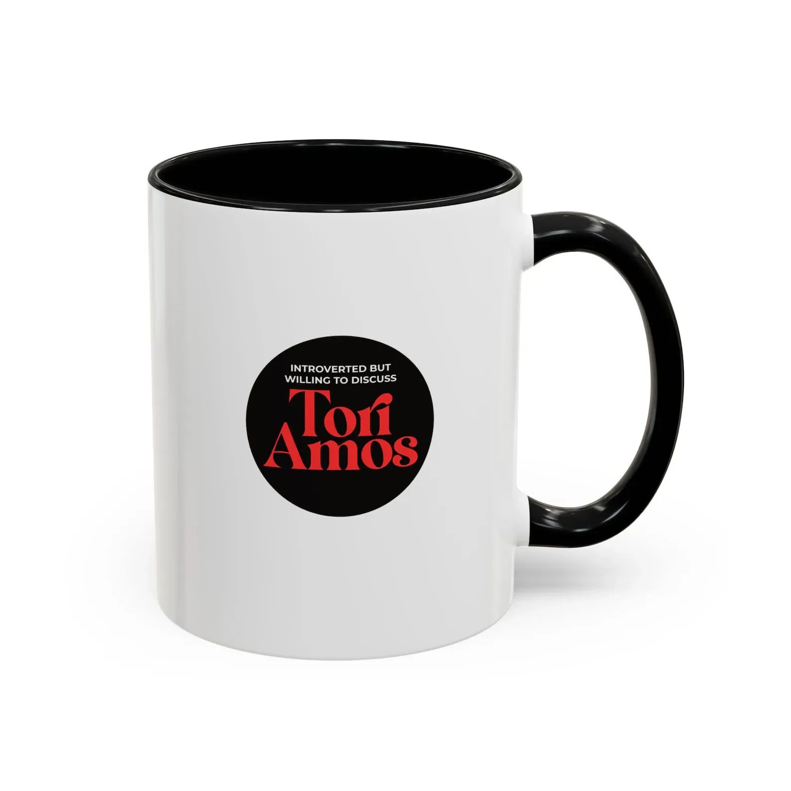 White coffee mug with black interior and handle, featuring a label with red and black text that says,"Introverted but willing to discuss Tori Amos."