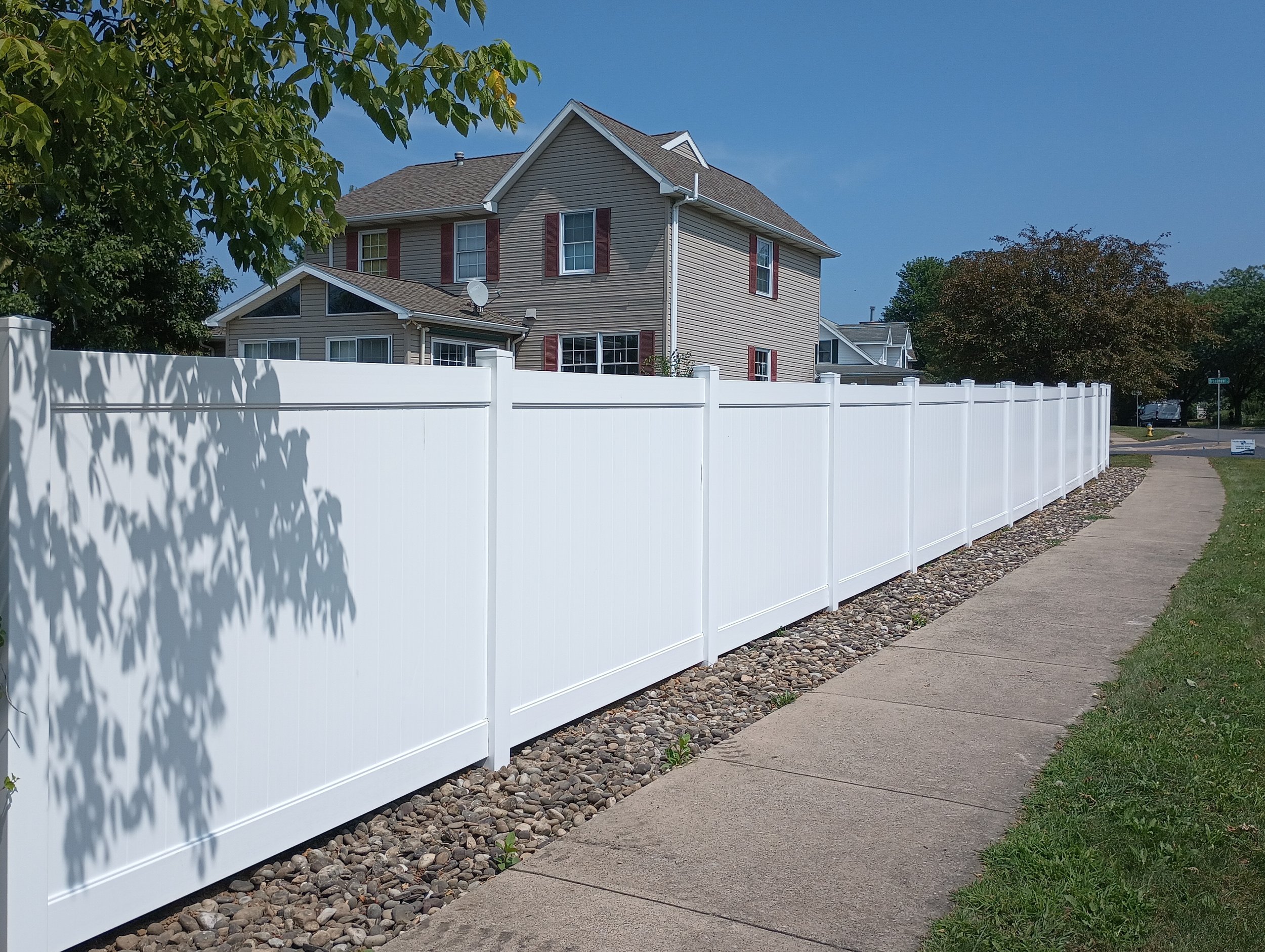 Vinyl fencing installation bordering a sidewalk for privacy