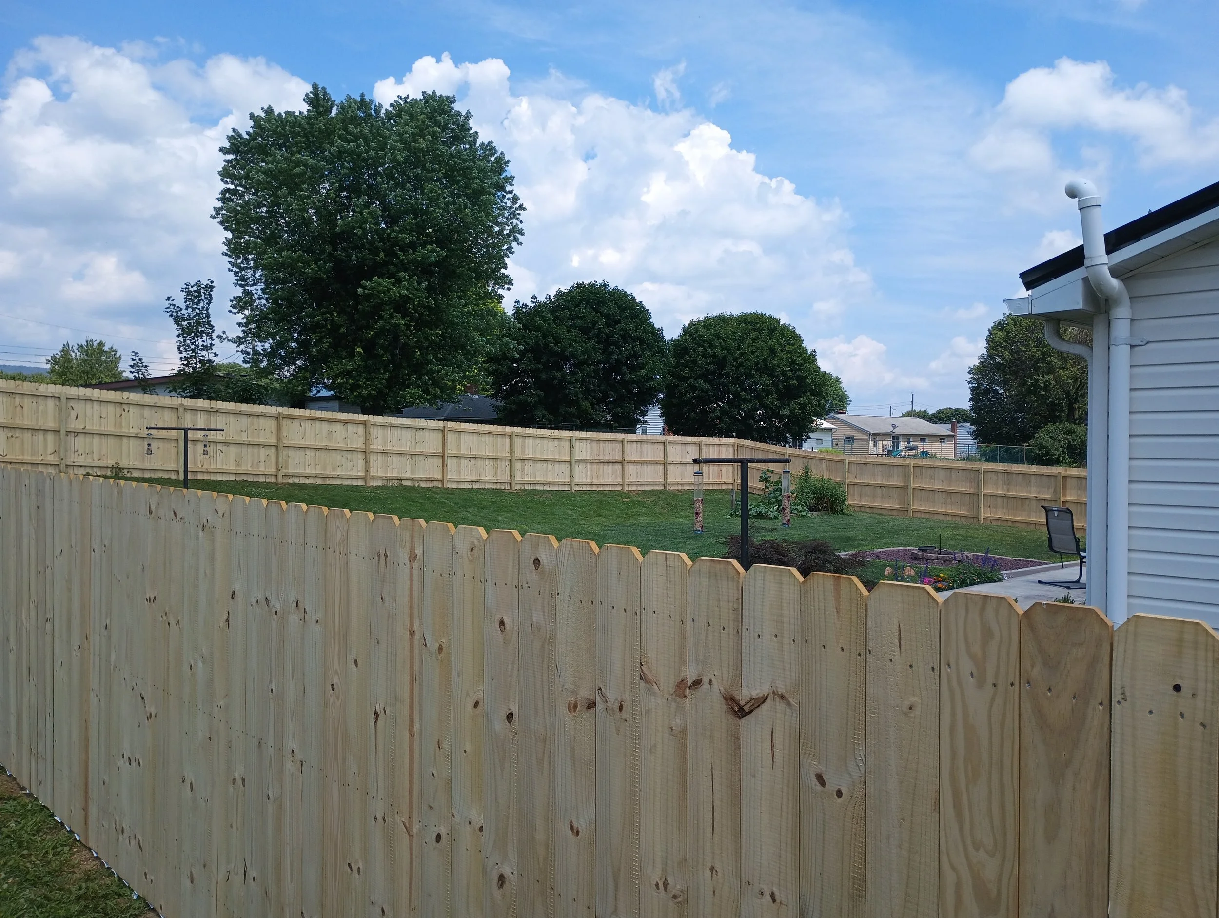Wooden fence installation surrounding a yard
