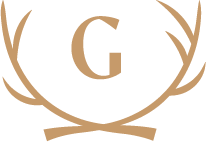 A logo with a brown letter 'G' inside a stylized circular wreath or laurel design.