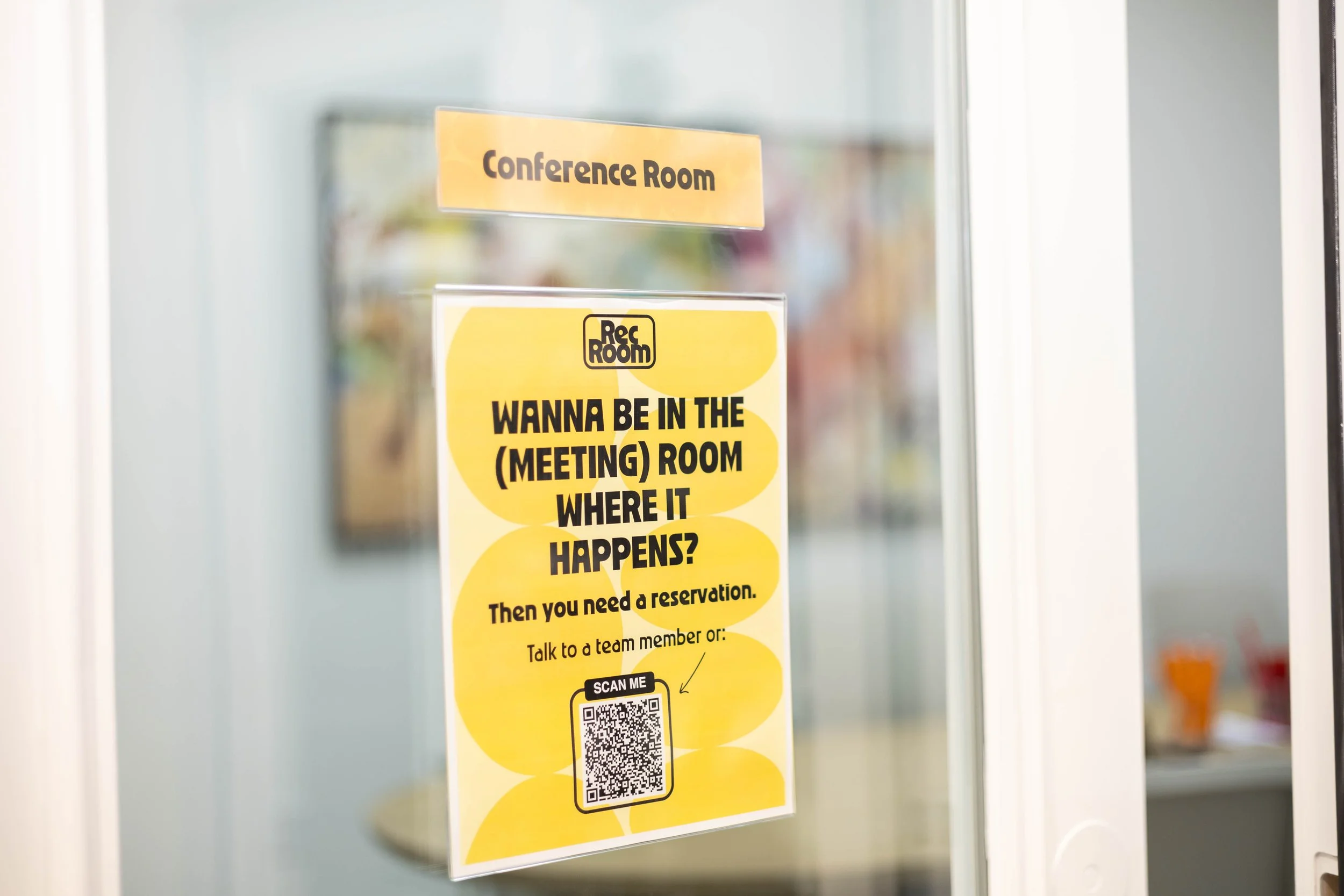 Sign on glass door for conference room and meeting reservation instructions, with a QR code for scanning.