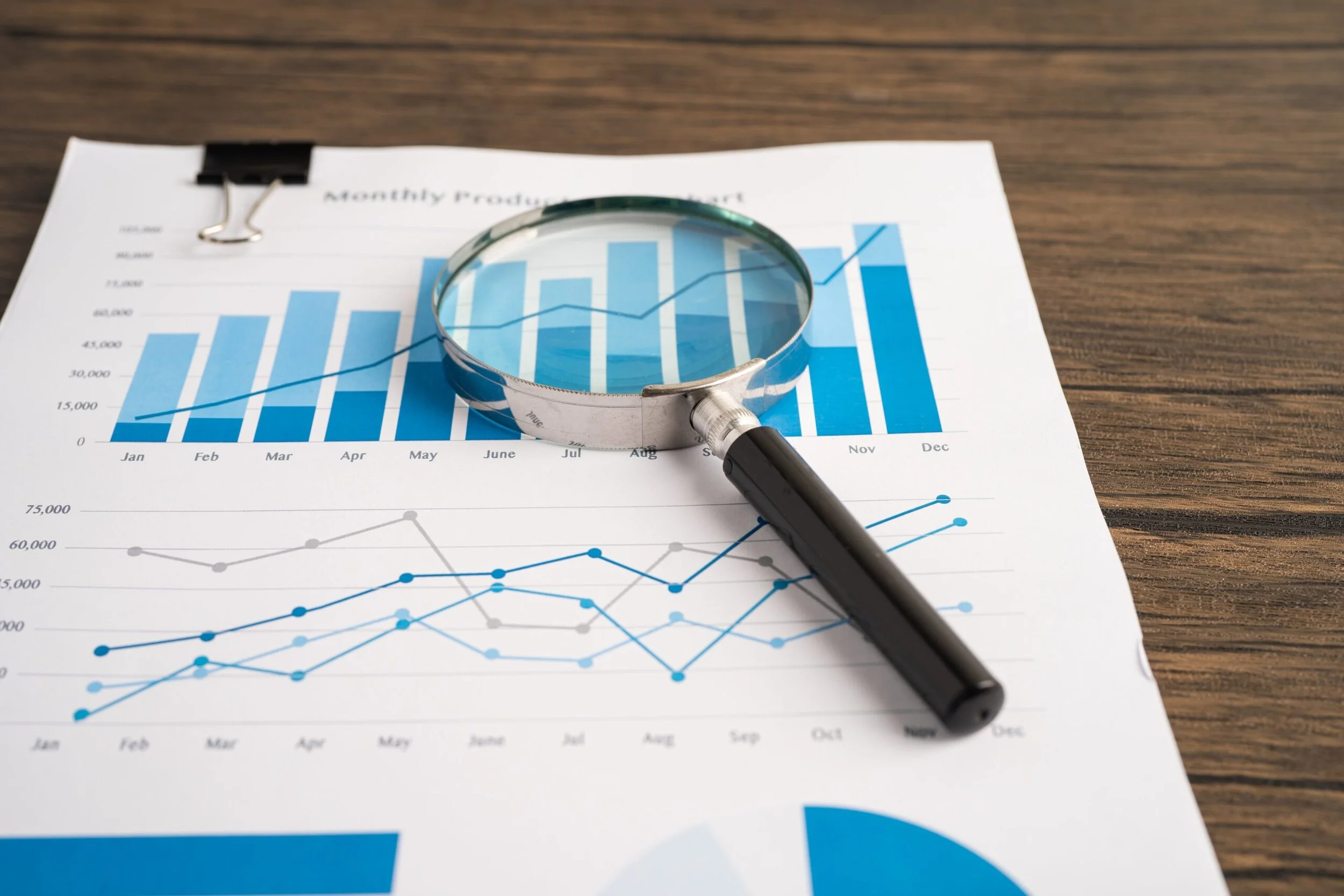 A magnifying glass resting on top of charts.