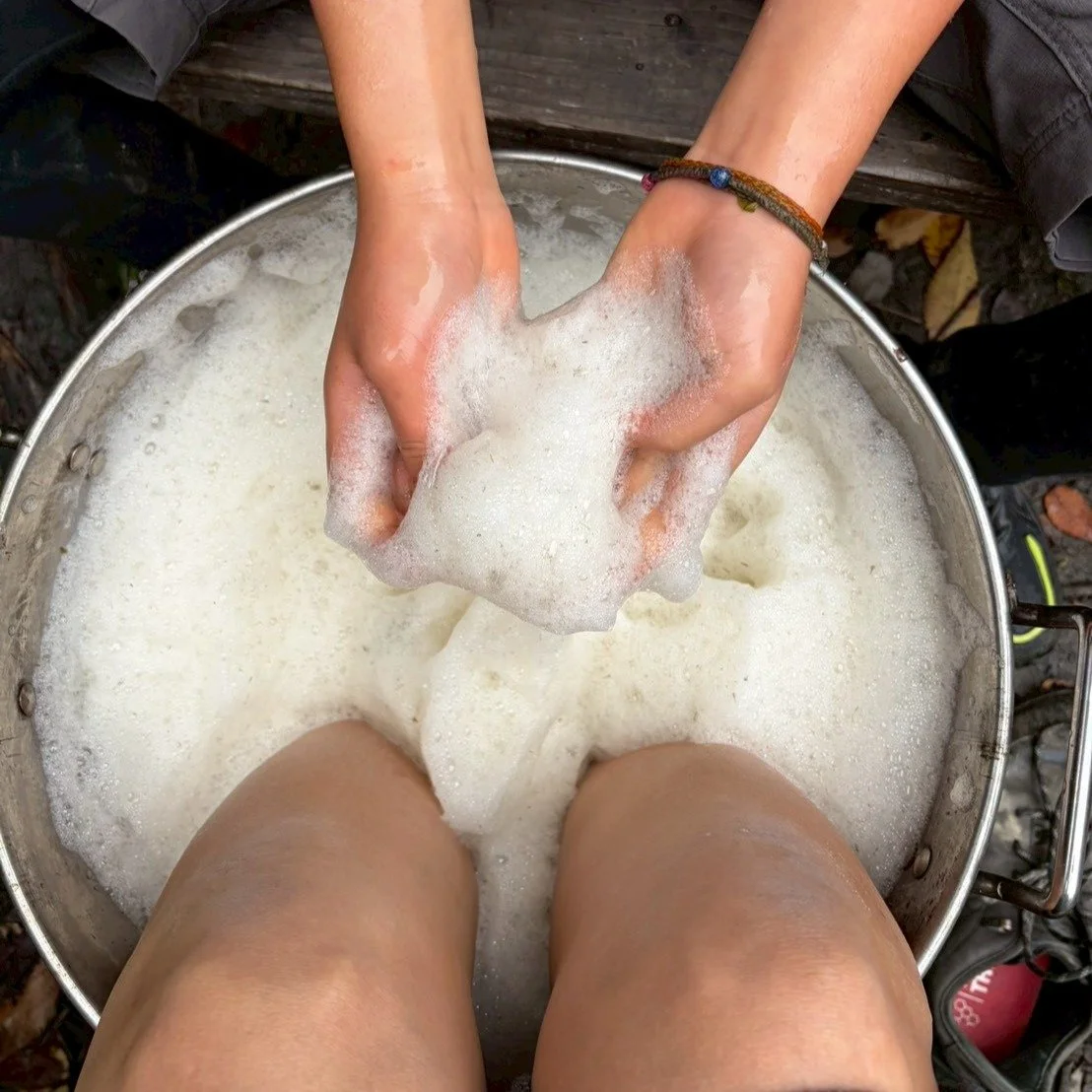 セイタカアワダチソウで染め物をした次の日。

染め終わった大なべの染め液は&hellip;肌に良いのでそのまま足湯にしました。
焚火で温めてかき混ぜるとすごく泡立つことに一同びっくり！
その名の通り、セイタカアワダチソウは泡立つのです。
そんないい香りのモコモコの泡に子どもたちは大喜び！
すると「これで泡風呂してみたい！」という声が😳それをきっかけに、泡風呂プロジェクトがスタート！🛁

ものすごいスピード感で、追加用のセイタカアワダチソウを採りにいく子、焚火をしてお風呂の準備をする子に分かれ