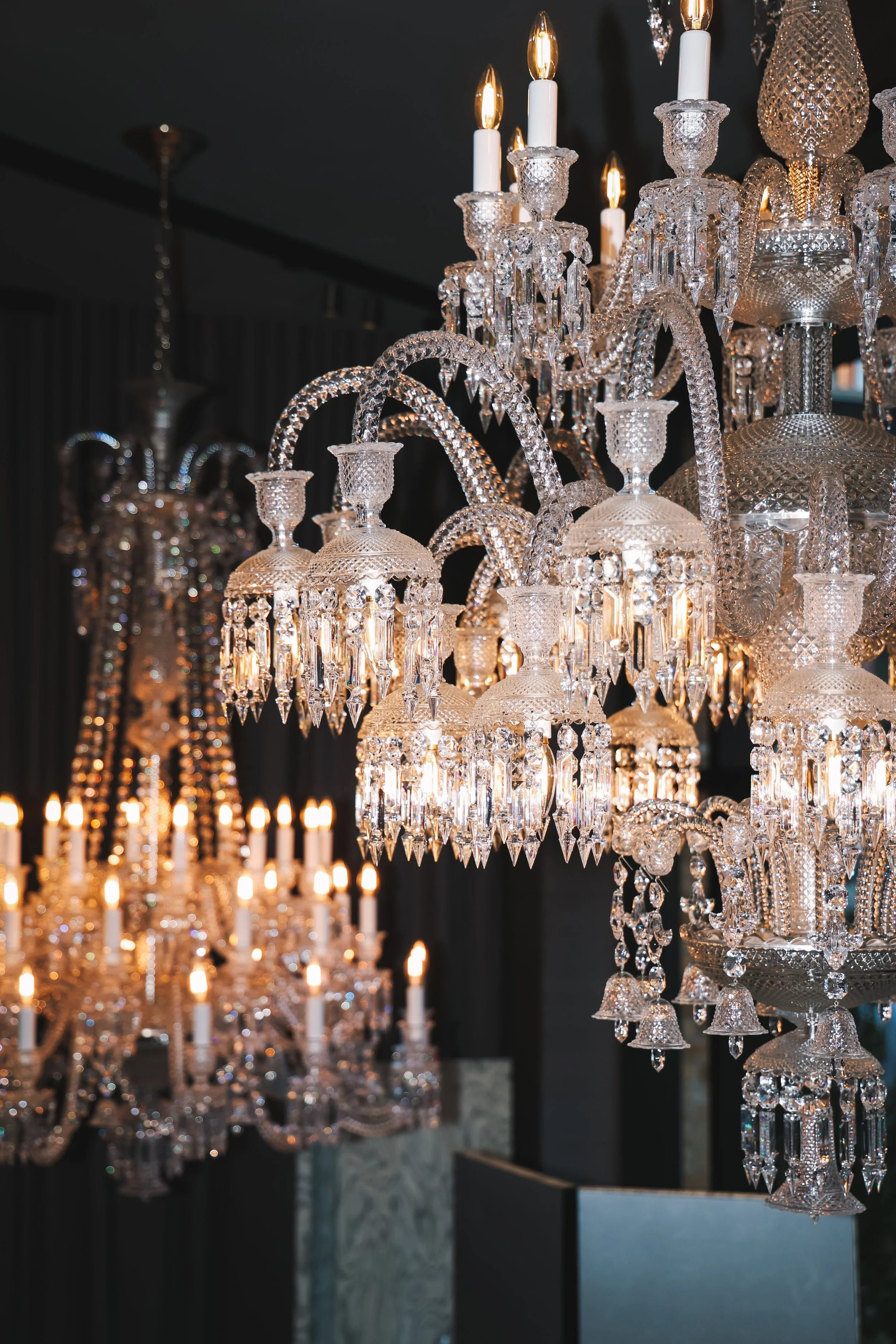 Elegant crystal chandelier with lit candle-shaped bulbs in a dark room.