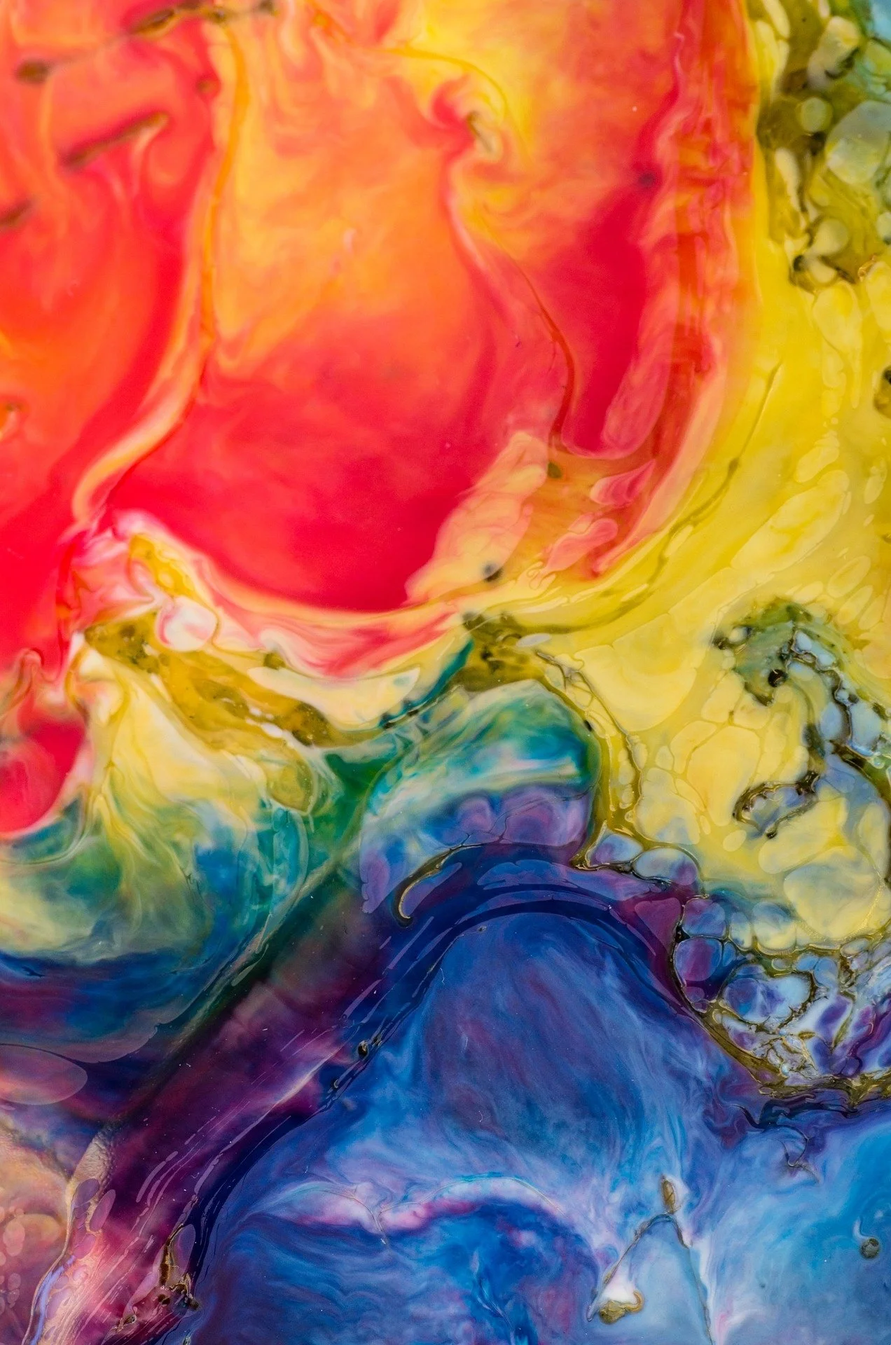 Abstract image with swirling colors of red, yellow, blue, and green.