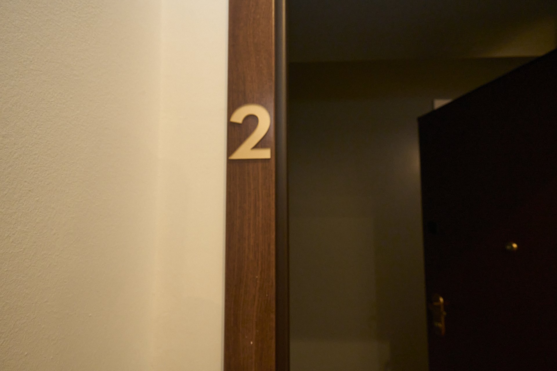 Porta con il numero 2 sulla cornice di legno in un ambiente di interni.