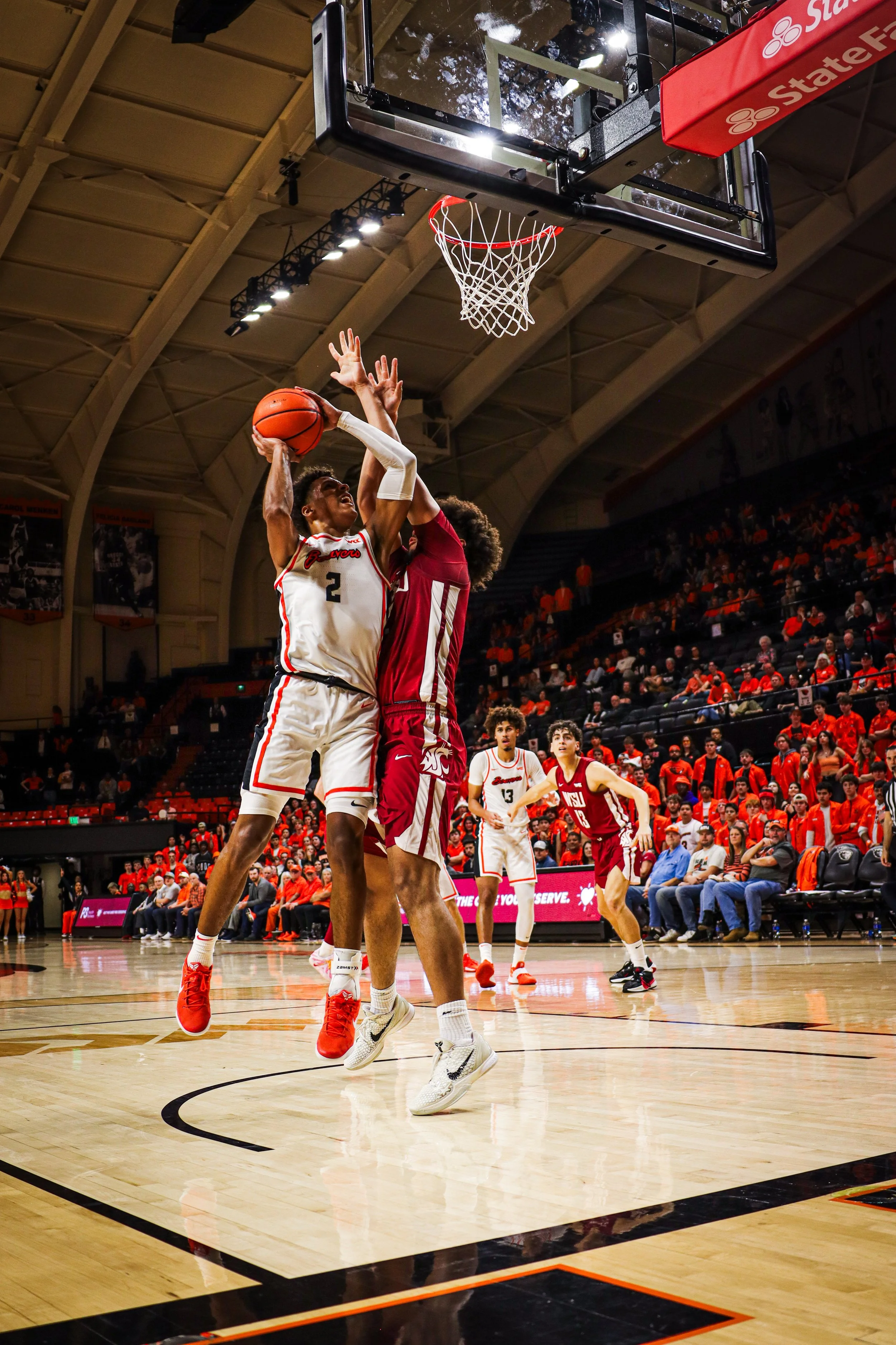 point guard taking a jump shot in college basketball game