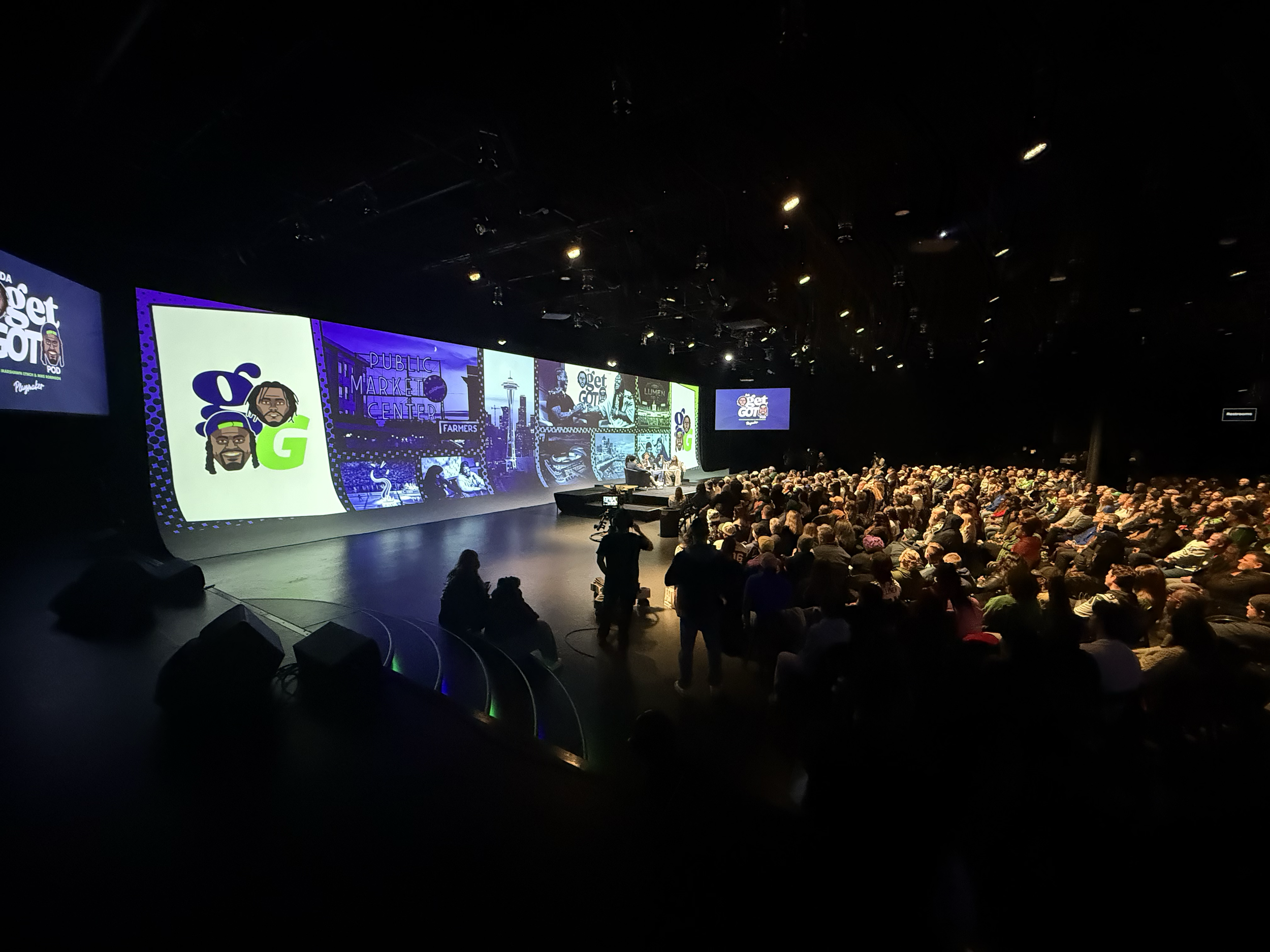 Wide view of the audience and stage during the Seattle live podcast