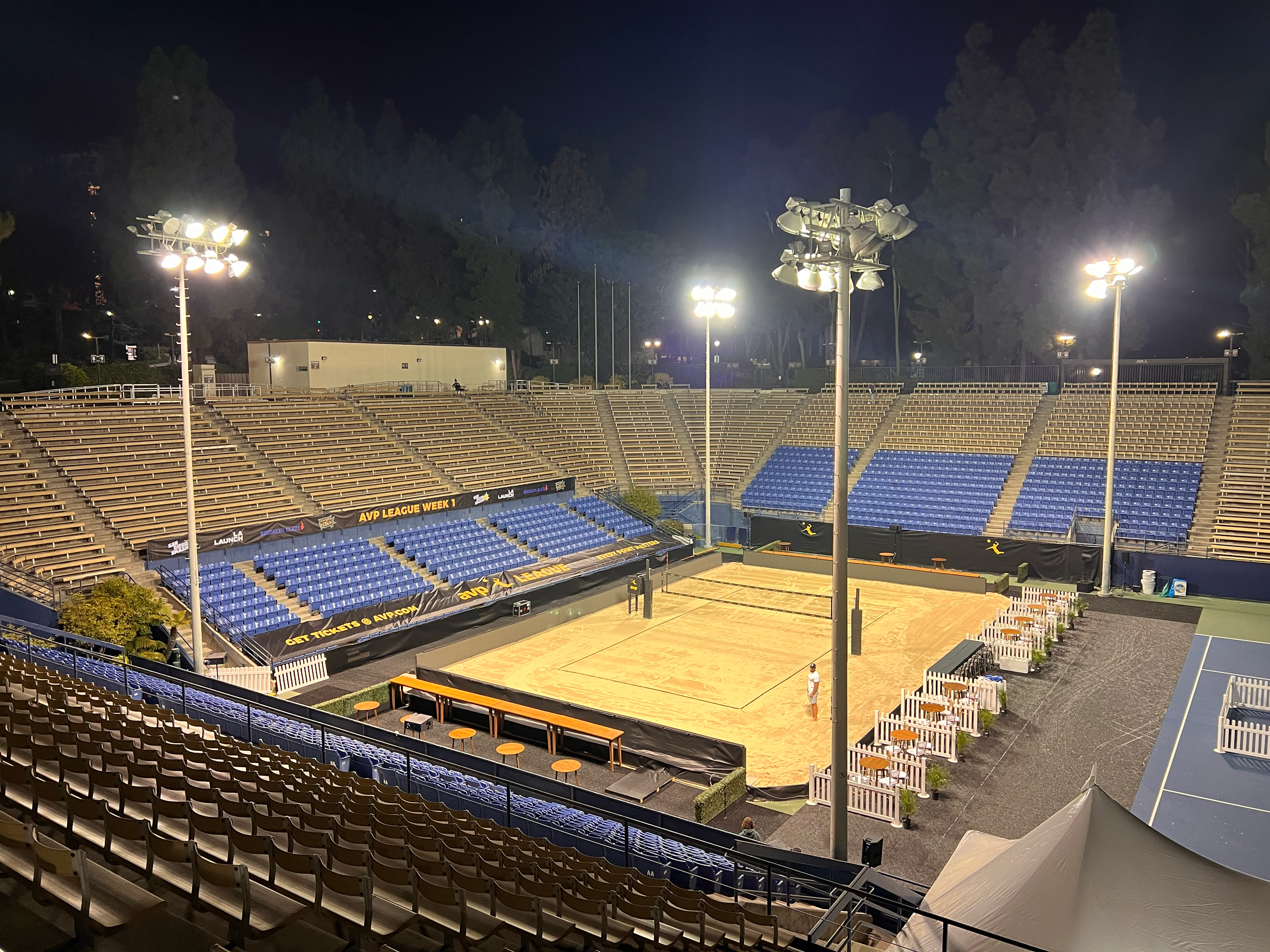 AVP volleyball court with stadium seating under event lights