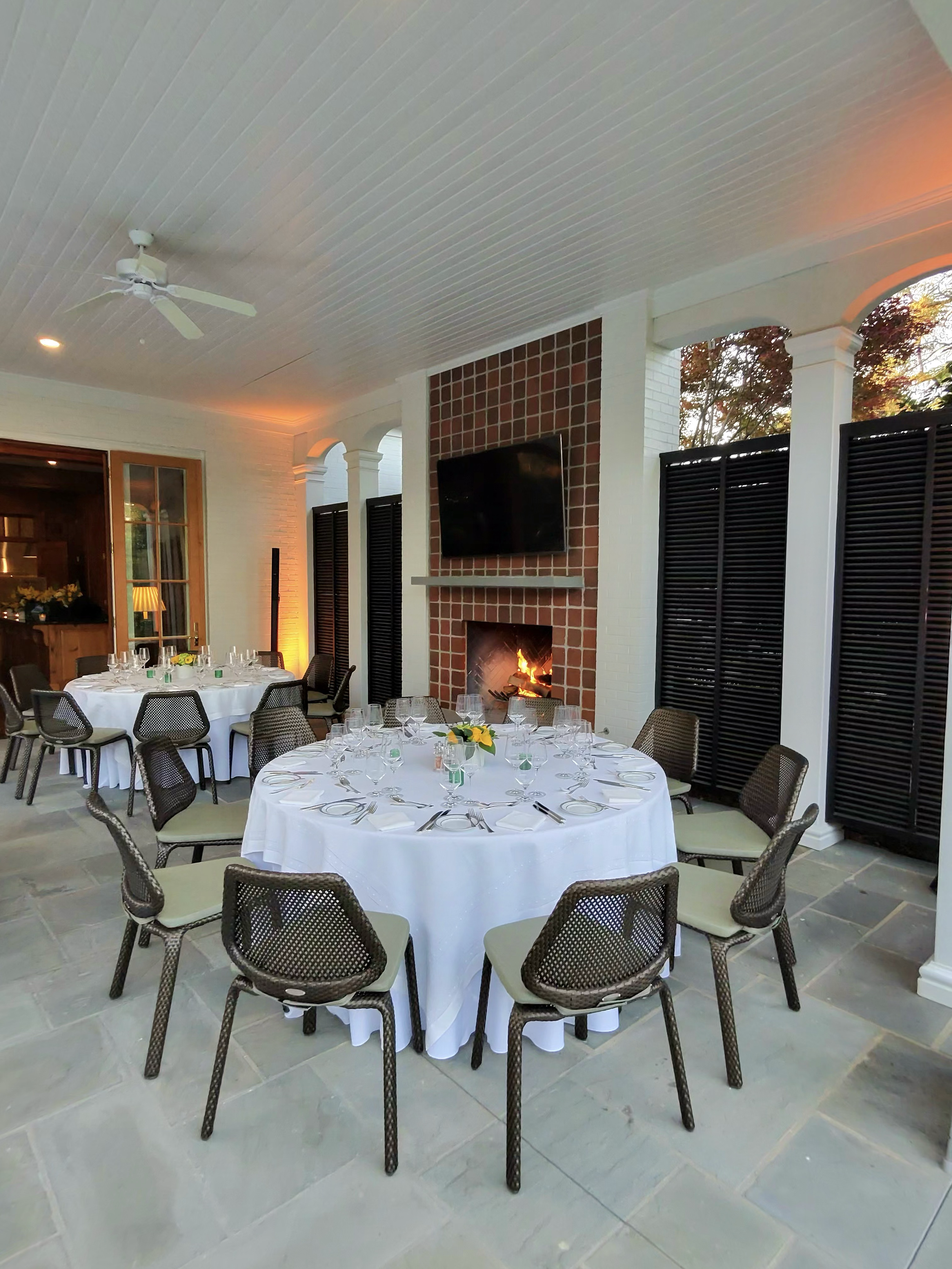 Set dining tables beside the fireplace at the Rolex Entertainment House