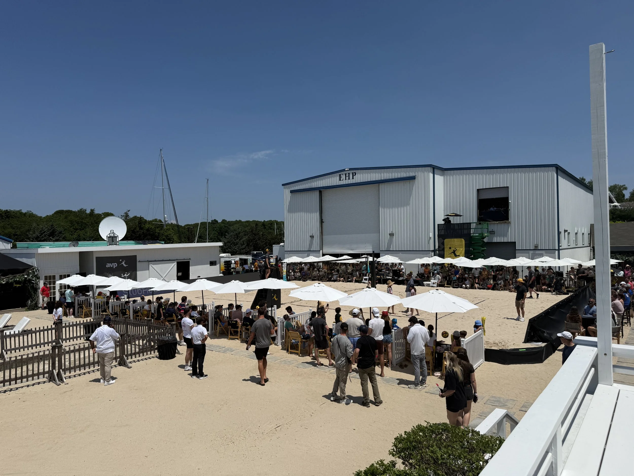 Outdoor AVP venue with spectators and hospitality areas