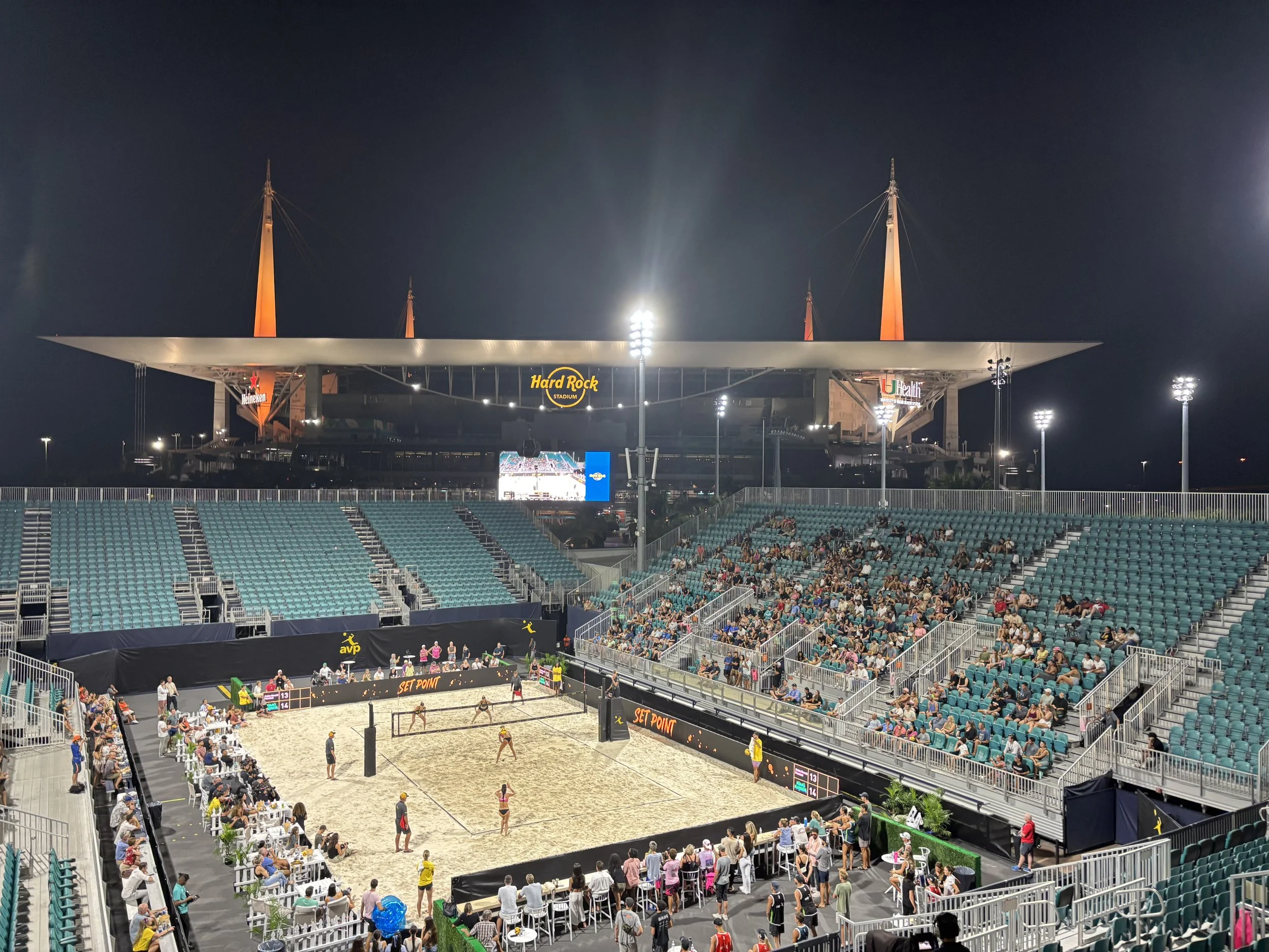 Outdoor AVP court illuminated for an evening match