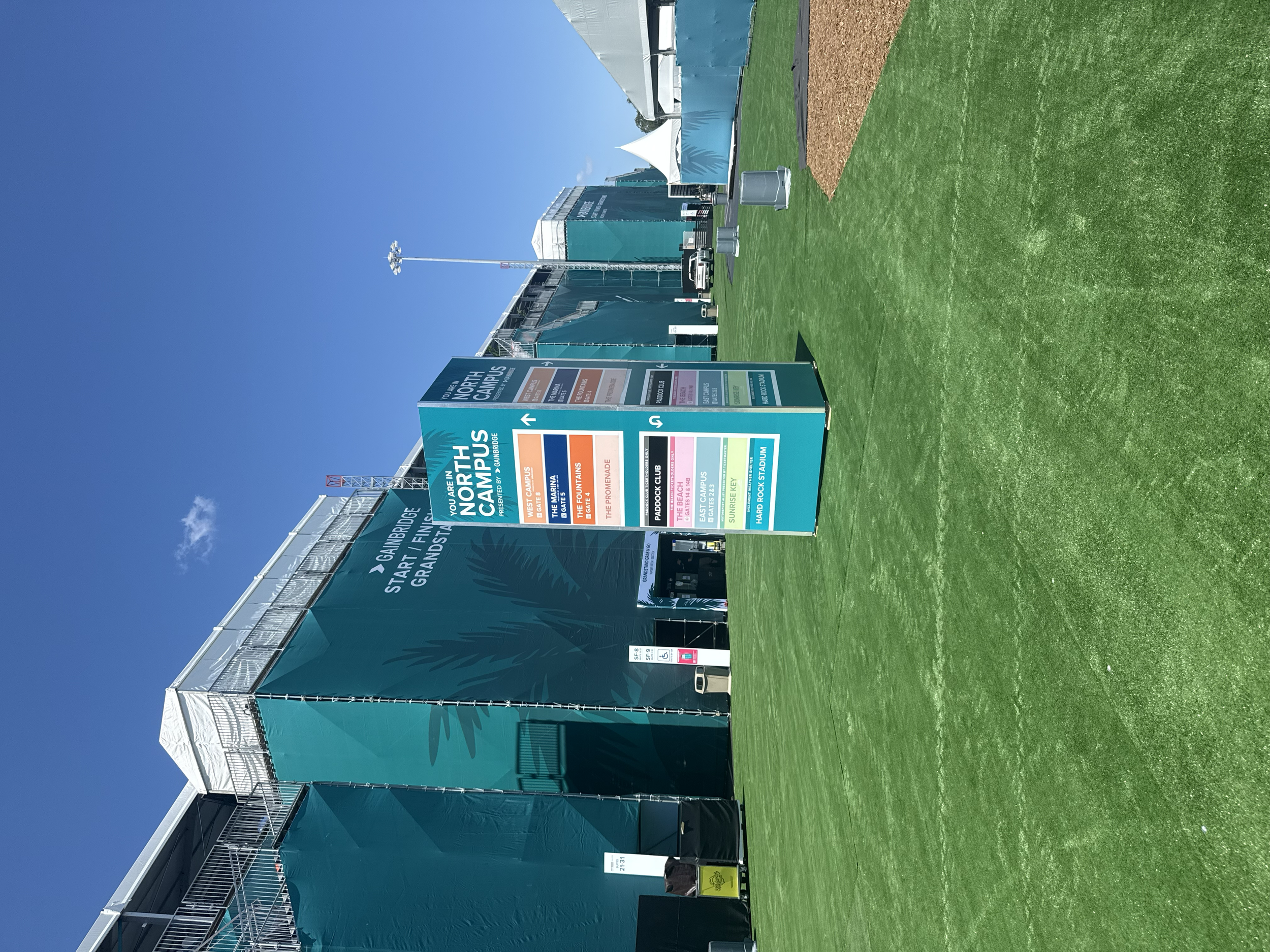 Wayfinding sign installed beside hospitality structures at the Miami Grand Prix