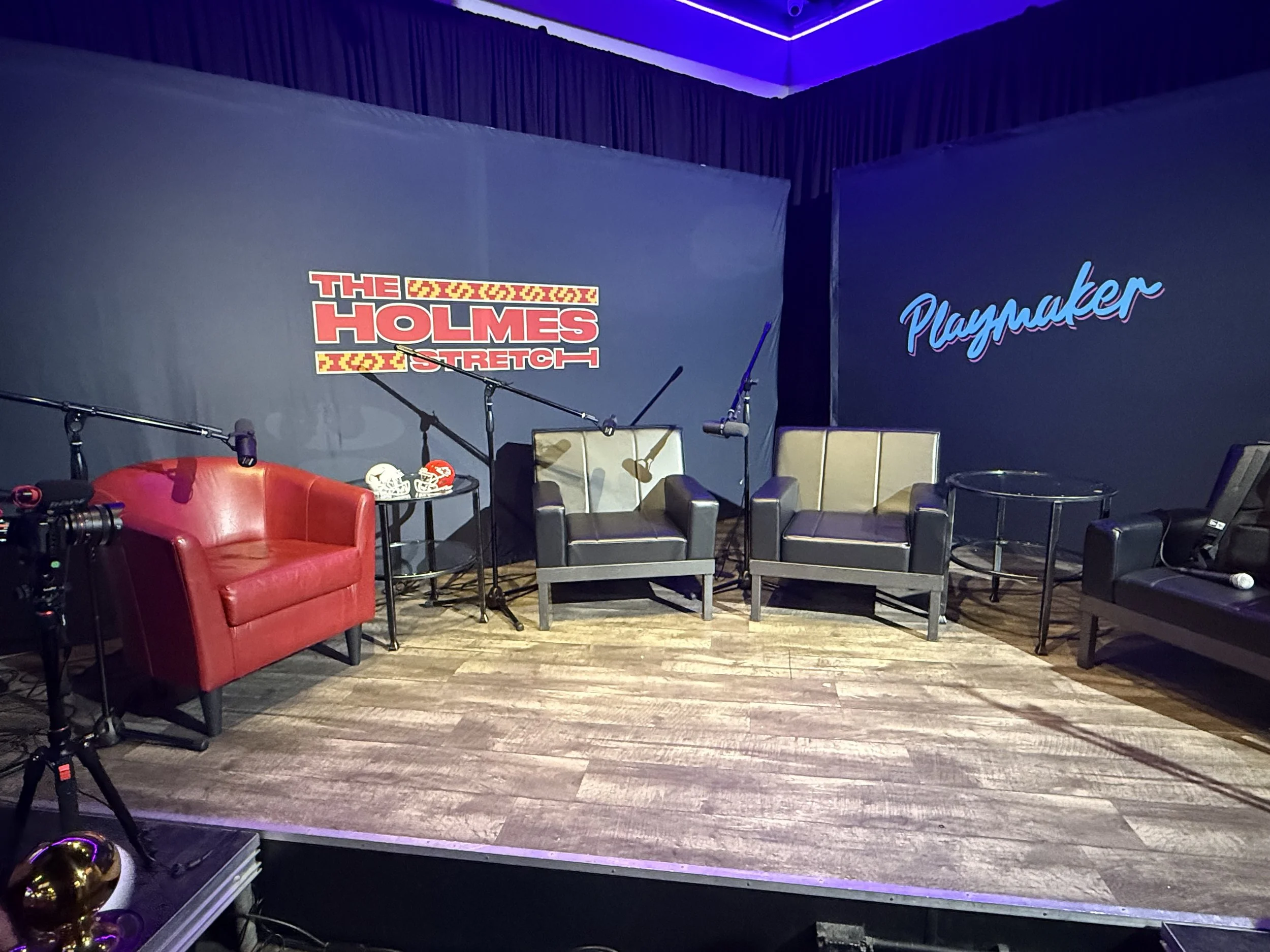 The Holmes Stretch podcast stage with lounge seating and microphones