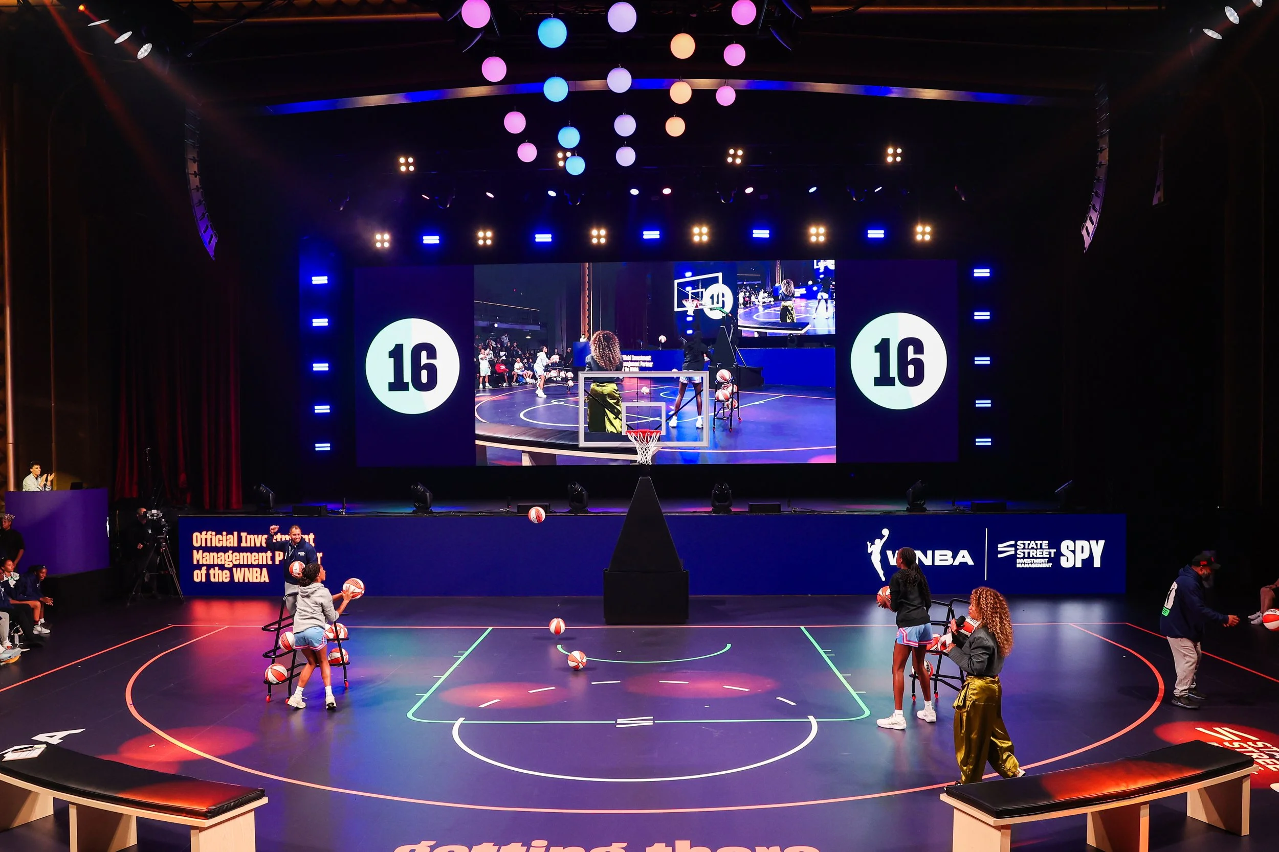 WNBA game shown on screens above the event court