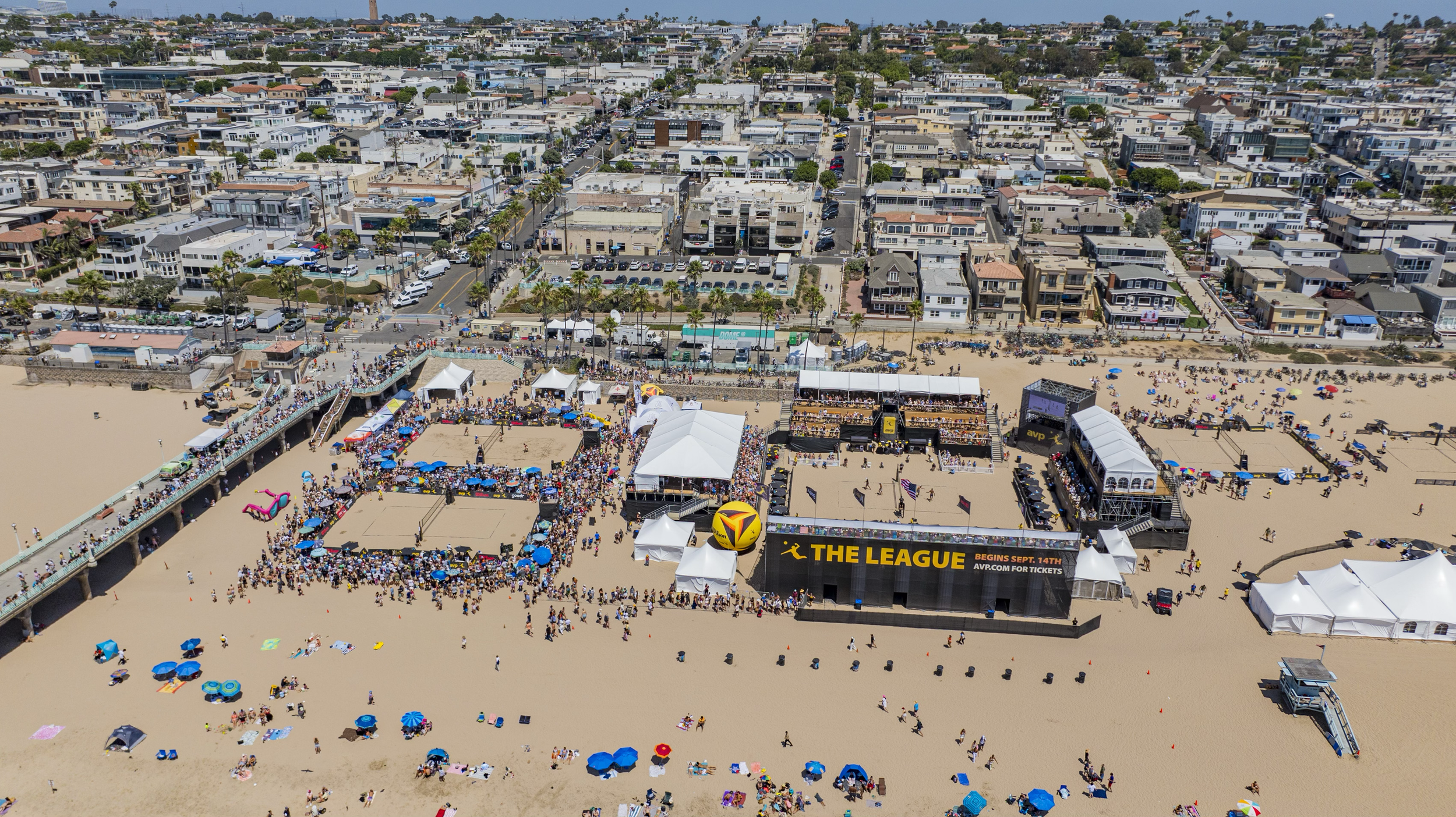 Aerial view of AVP courts and hospitality beside the beachfront neighborhood