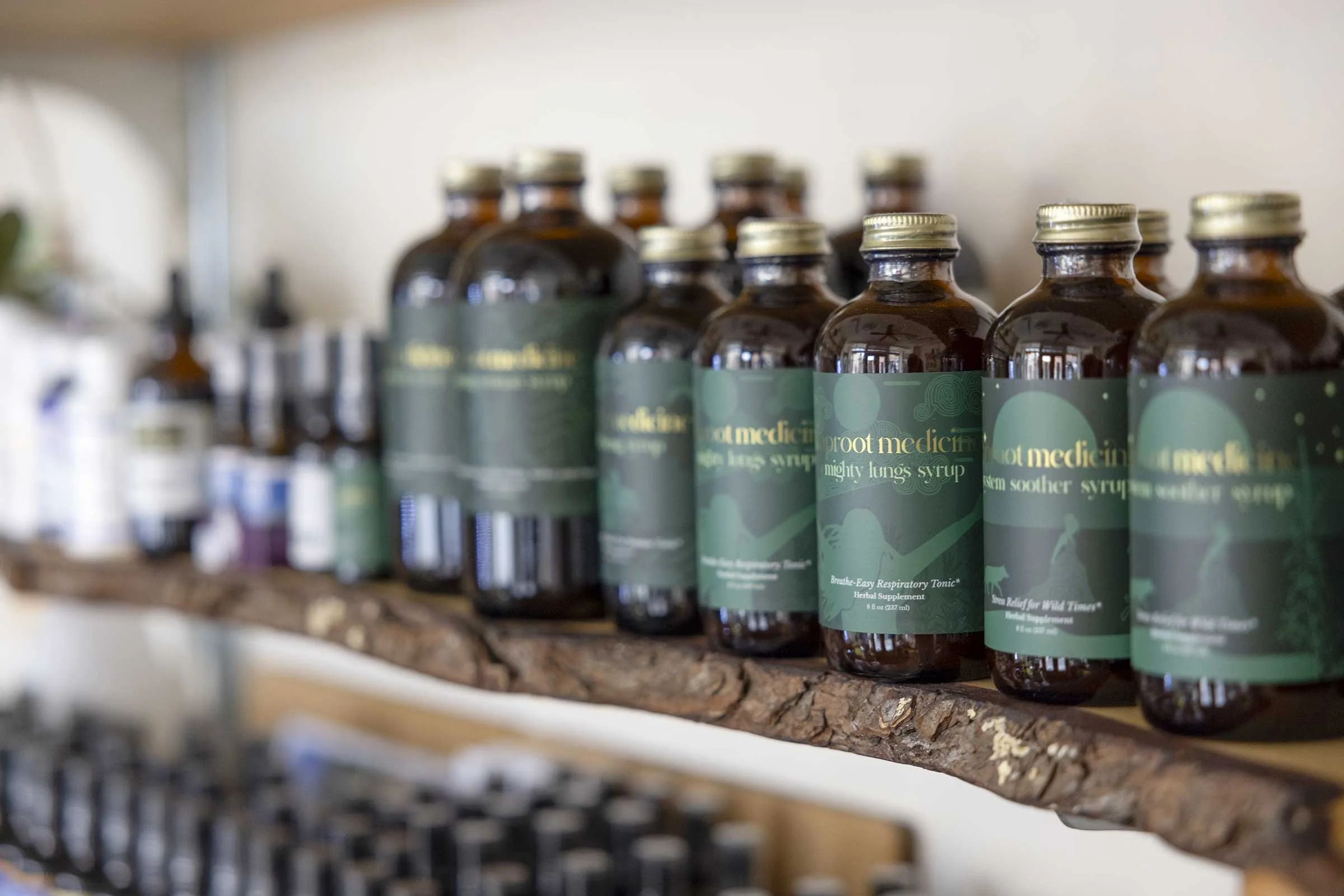 Row of herbal remedy bottles on a wooden shelf.