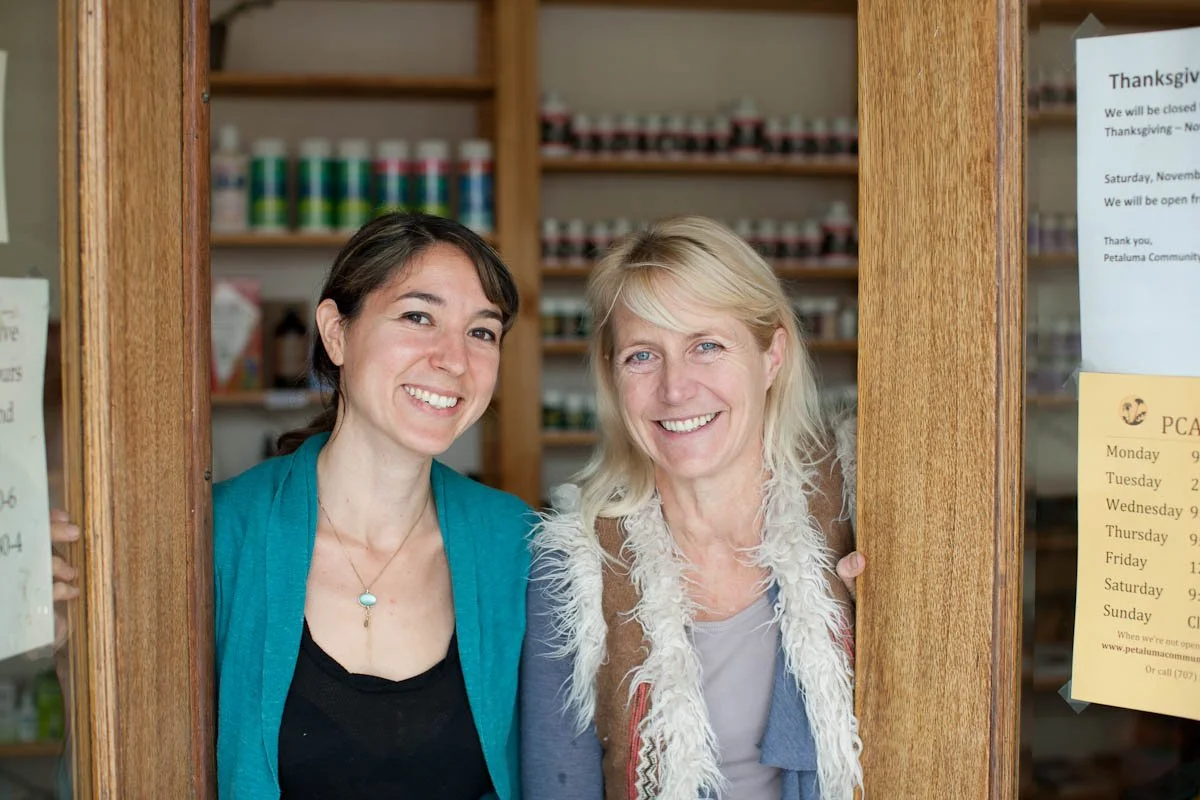 The two founders of Petaluma Community Acupuncture smiling and standing in the doorway of their Petaluma location in California's North Bay
