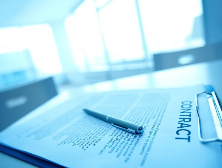 Close-up of a contract on a clipboard with a pen