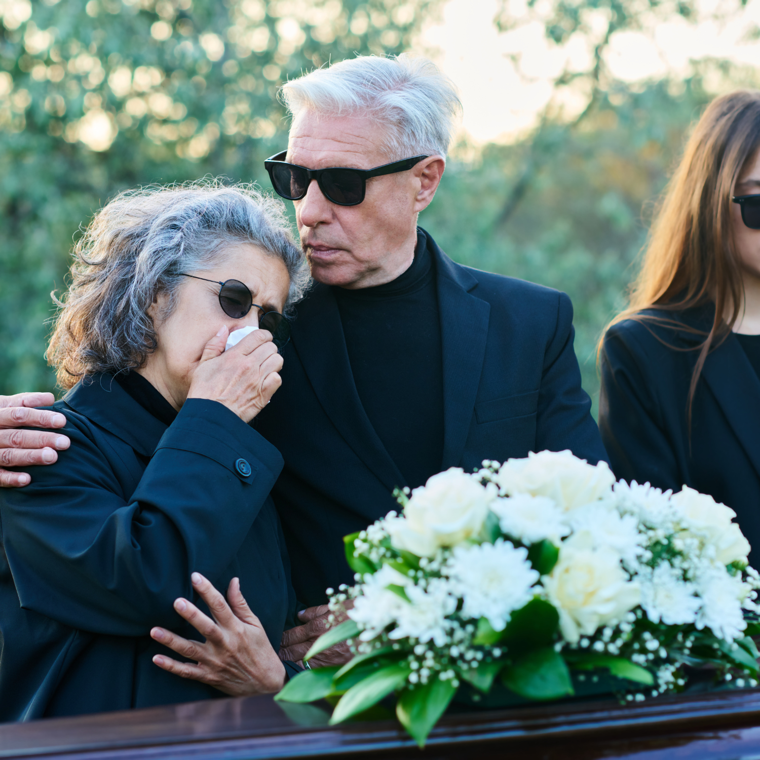 white flowers displayed at funeral while family mourns
