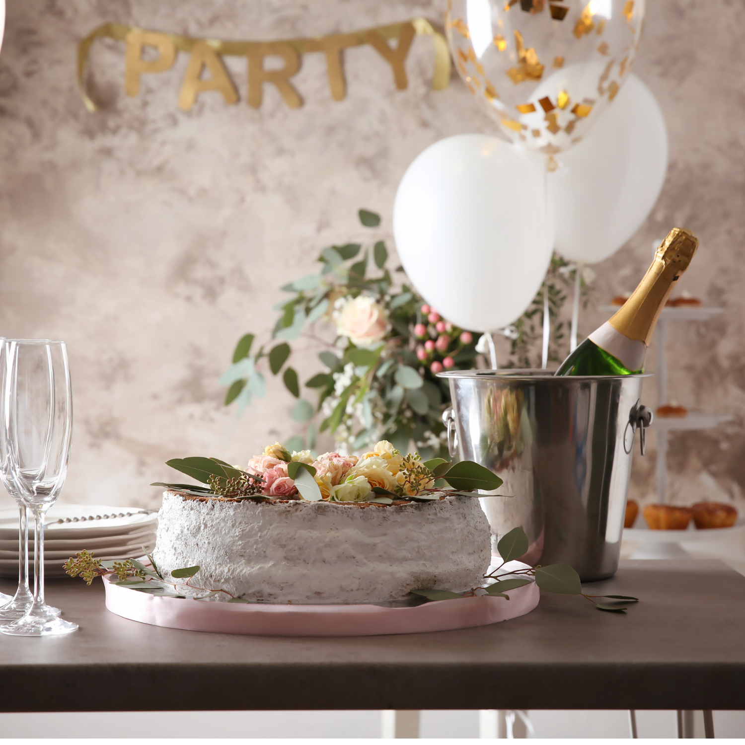 Flowers on a cake with bottle of champagne