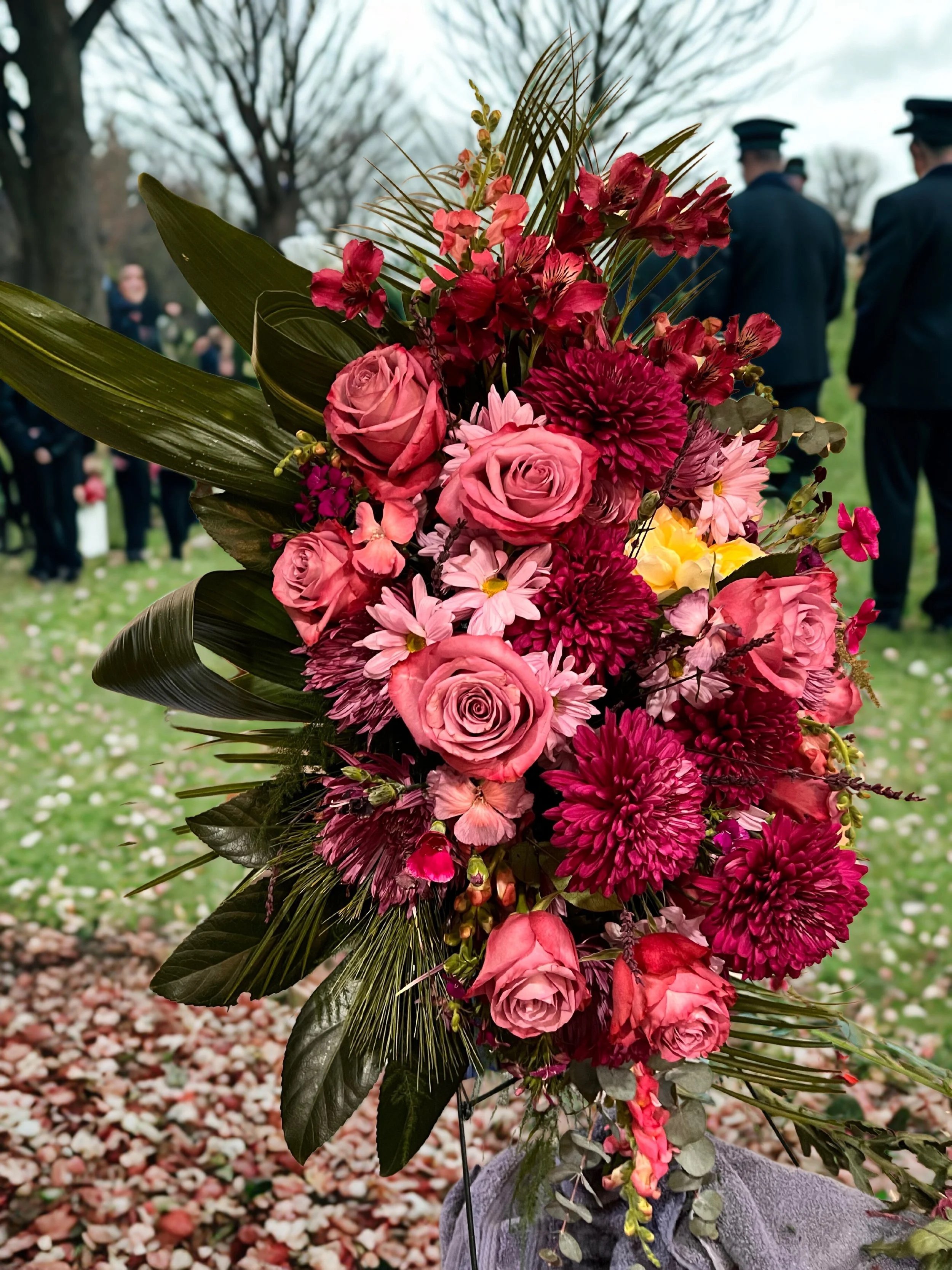 flowers in the burgundy to pink hues arranged for funeral spray