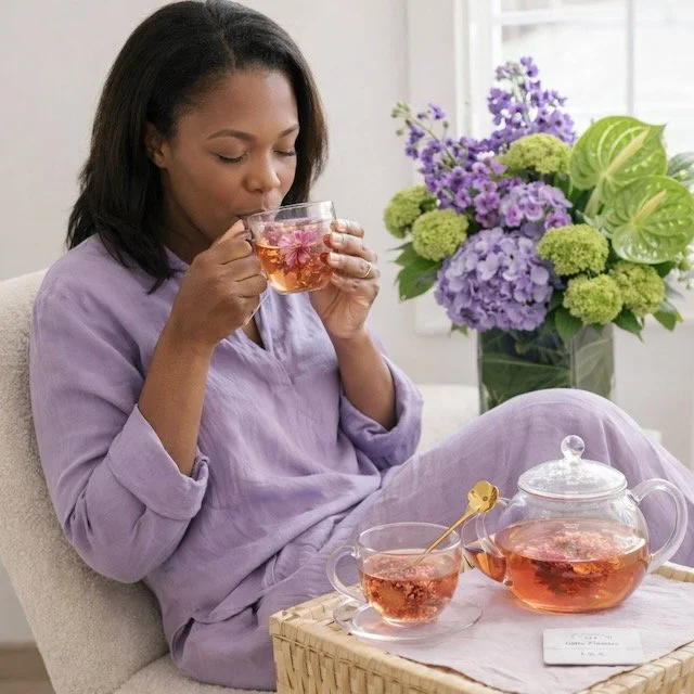 The Botanical Ritual woman sipping tea admiring mothers day gifts of flowers by TA