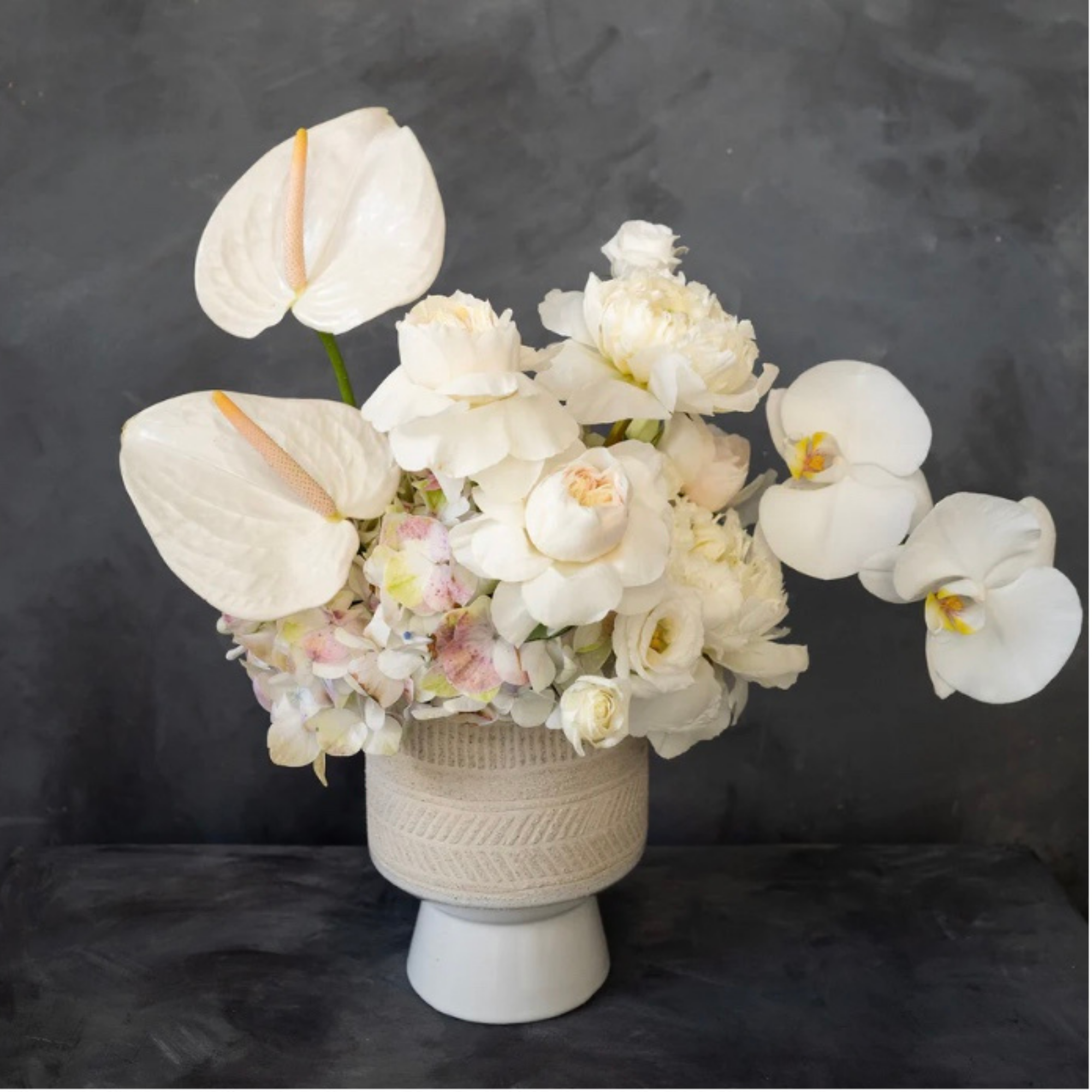 Modern sympathy floral design featuring premium blooms such as anthurium and orchid, shown as studio design inspiration.