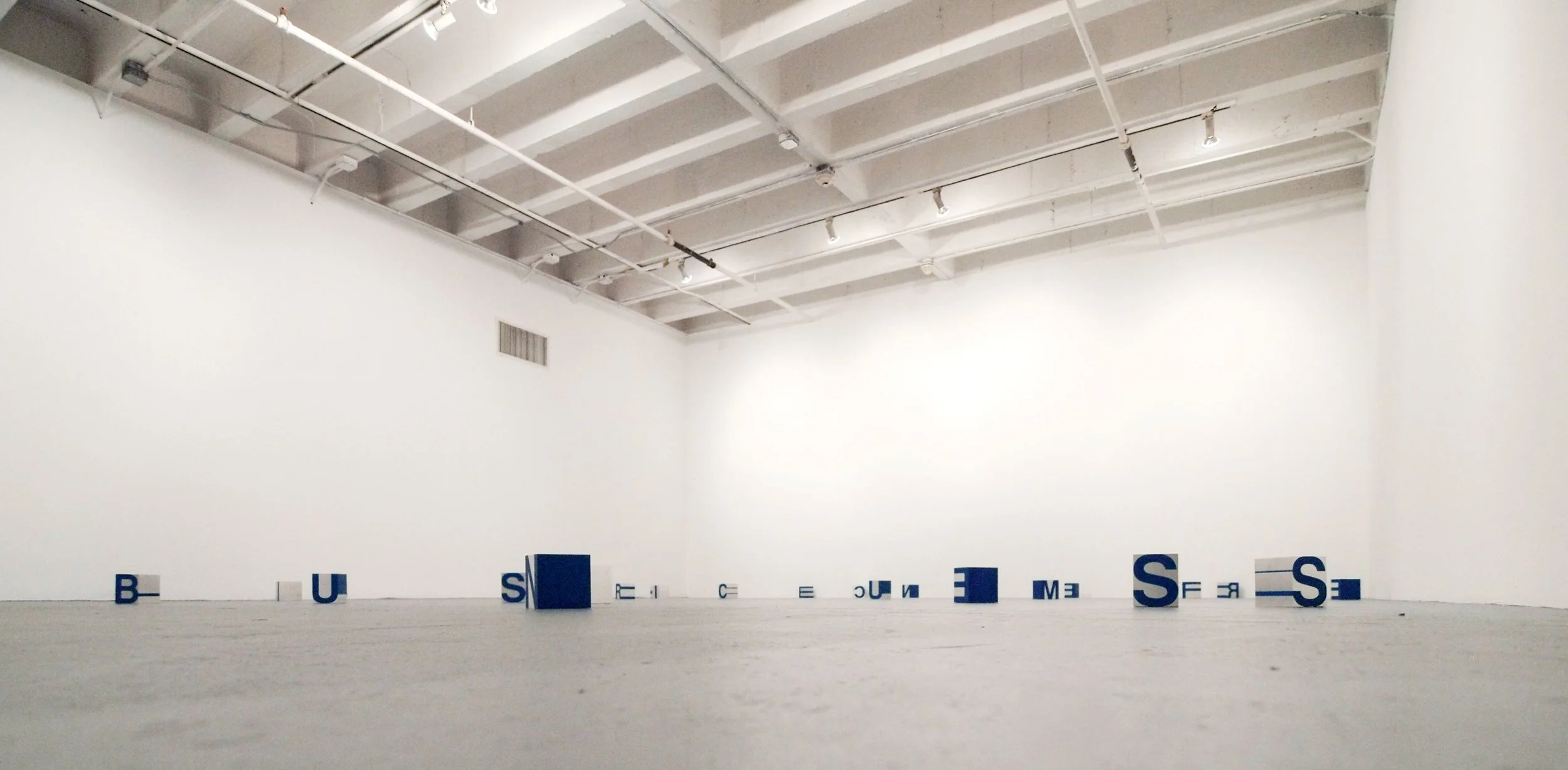 Installation view of Don't Look Back MoCA exhibit comprised of scattered blue and white letter boxes designed by Sparano + Mooney Architecture