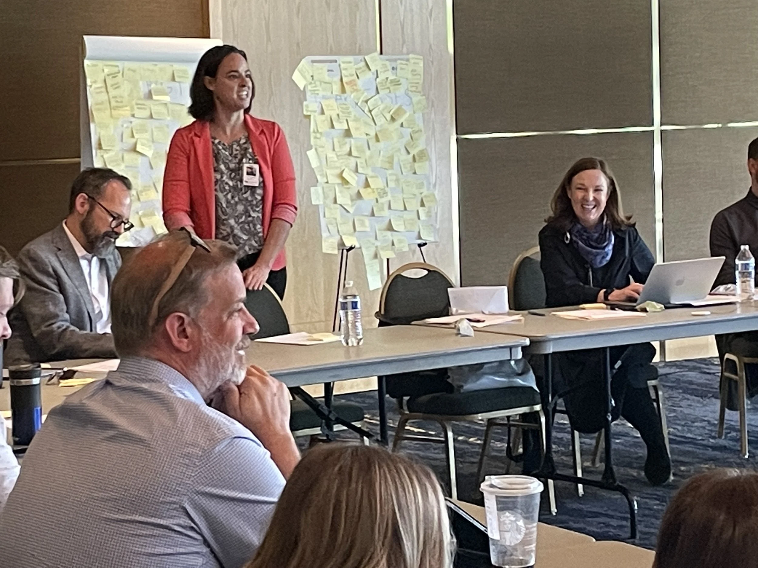 A group of people in a room seated around a U-shaped table, taking part in a stakeholder outreach sessions for the Abravanel Hall Visioning Project, led by Sparano + Mooney Architecture