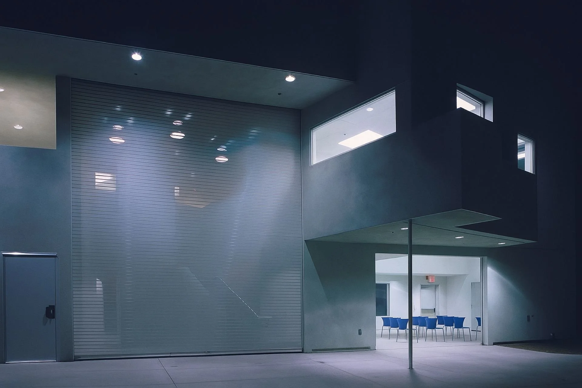 Night perspective of the transparent gate covering exterior entrance to facility designed by Sparano + Mooney Architecture