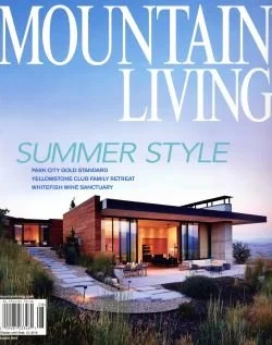 Magazine cover titled 'Mountain Living' featuring a modern mountain house with large windows, outdoor seating area, and scenic mountain view in the background.