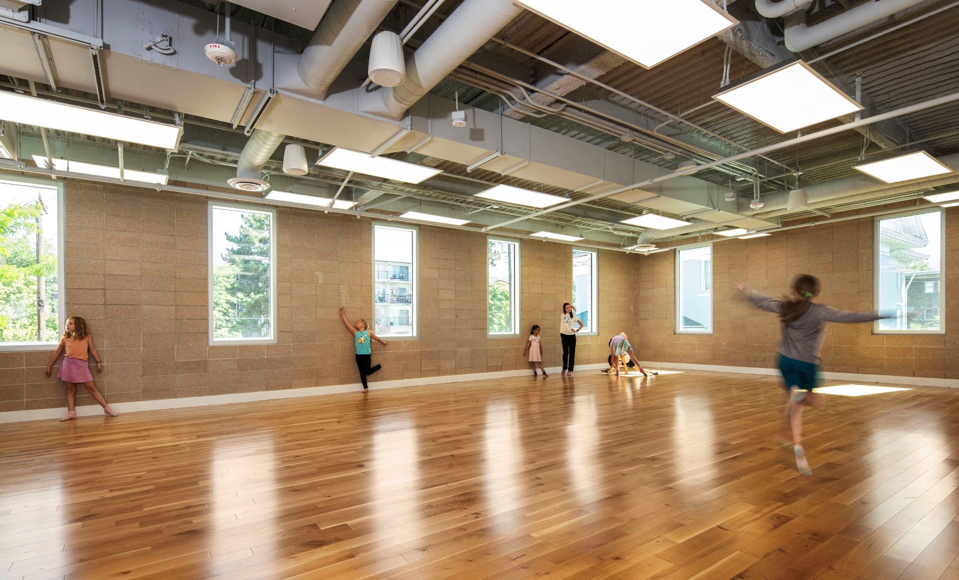 Children dancing in bright studio designed by Sparano + Mooney Architecture