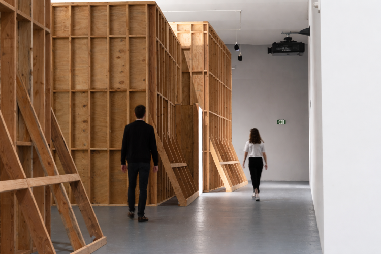 People walking behind wooden framed structure of Paul Pfeiffer's MOCA exhibit designed by Sparano + Mooney Architecture