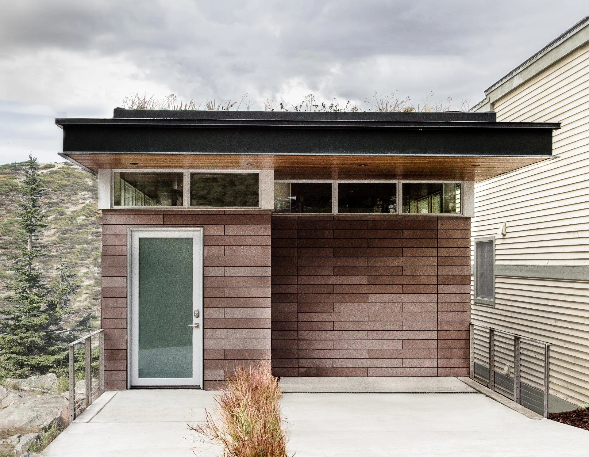 Brick facade elevation of a Park City residence with clerestory windows and a green roof by Sparano + Mooney Architecture