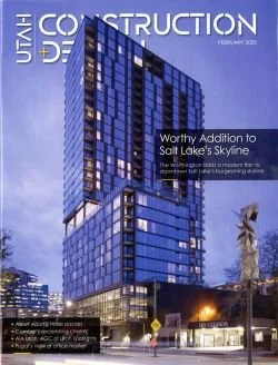 Magazine cover featuring a modern blue glass building in Salt Lake City with palm trees in the foreground. Title reads 'Worthy Addition to Salt Lake's Skyline'.