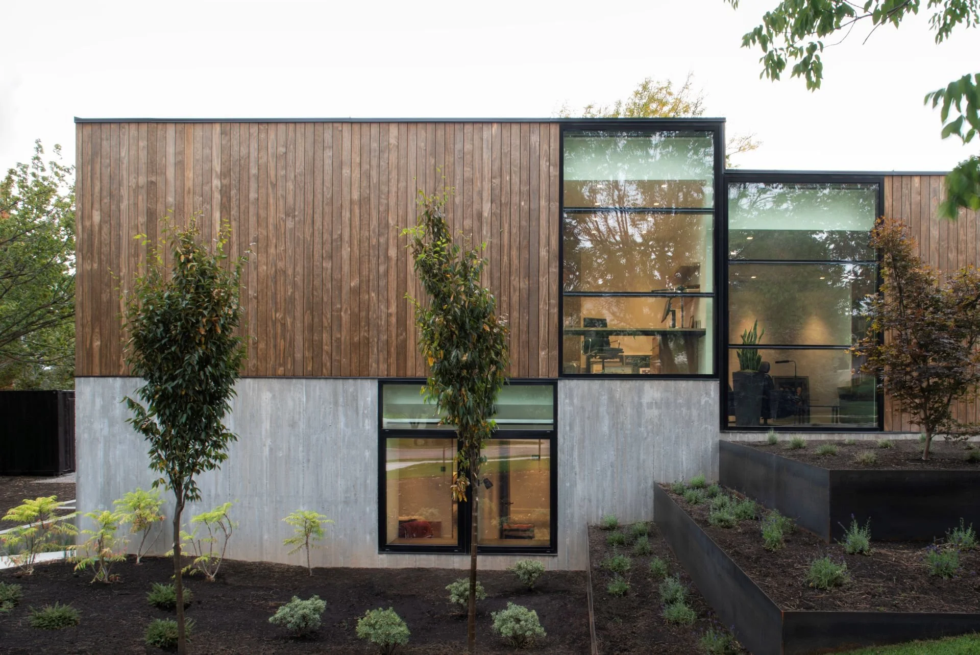 Front elevation of Emigration Creek Residence with wood and concrete facade and landscaped yard designed by Sparano + Mooney Architecture